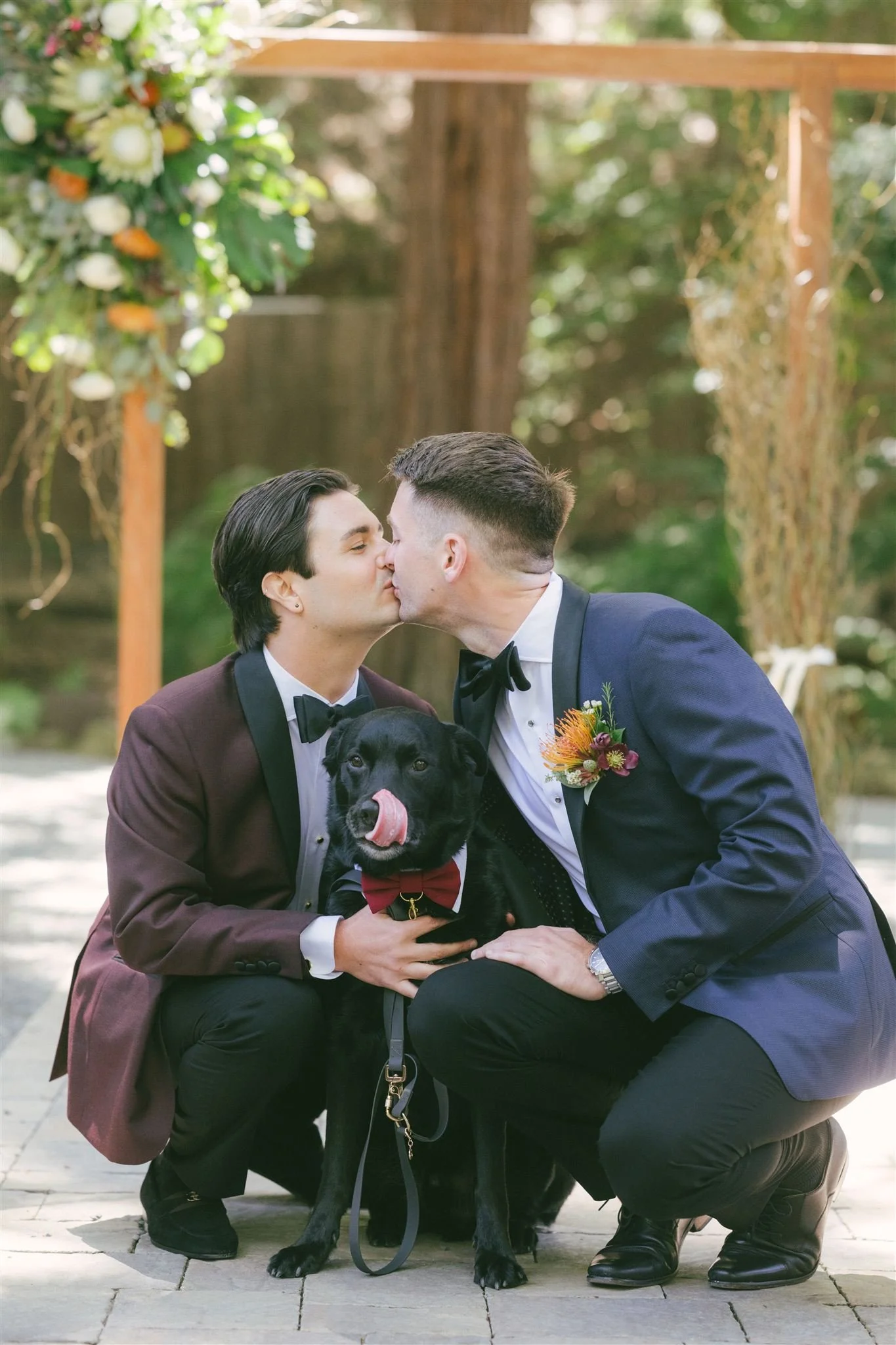 Two grooms posing  with their black labrador at Deer Park Villa