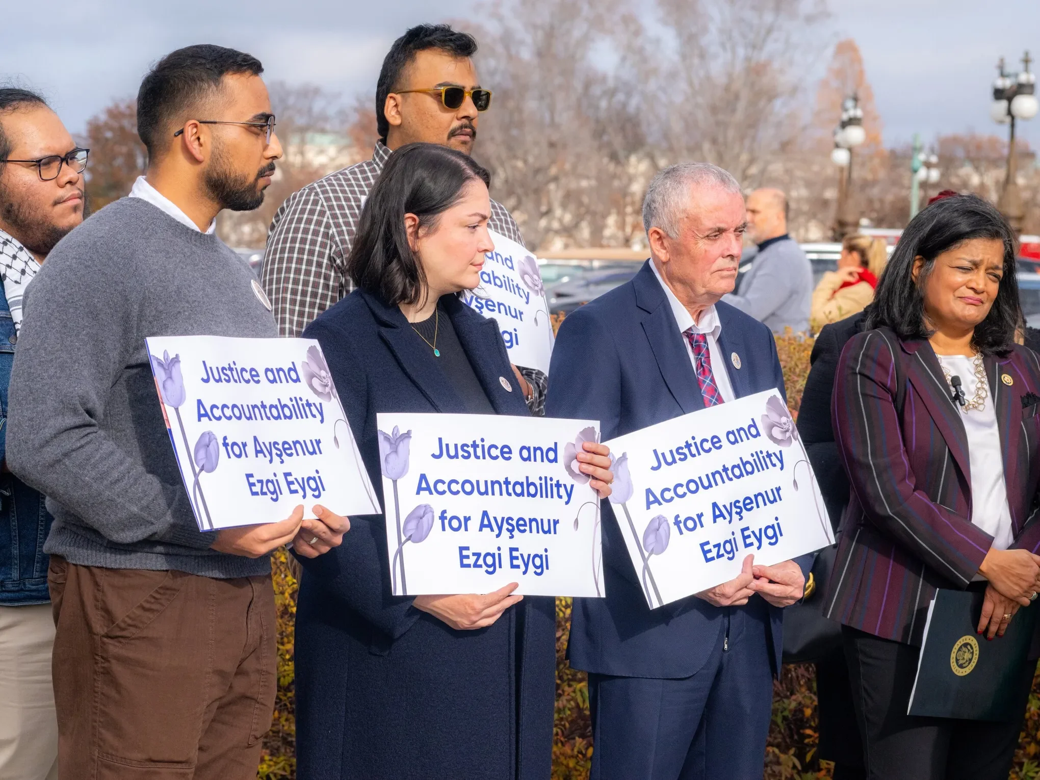 Group of diverse people holding signs that read "Justice and Accountability for Aysenur Ezgi Eygi" during an outdoor demonstration or rally.