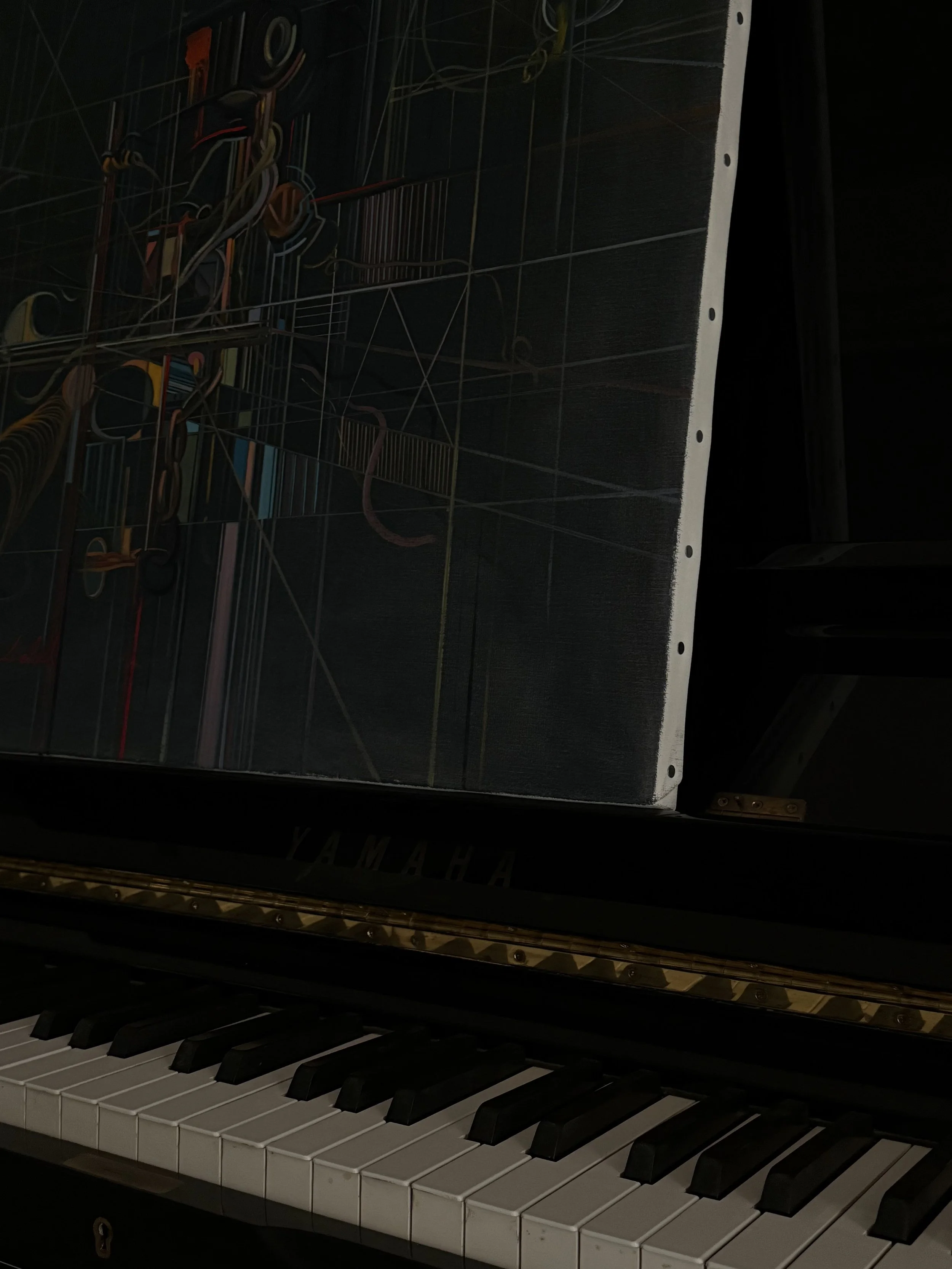 Clavier de piano noir et blanc avec une peinture posé à la place des partitions de musique. Image sombre pour le côté artistique.