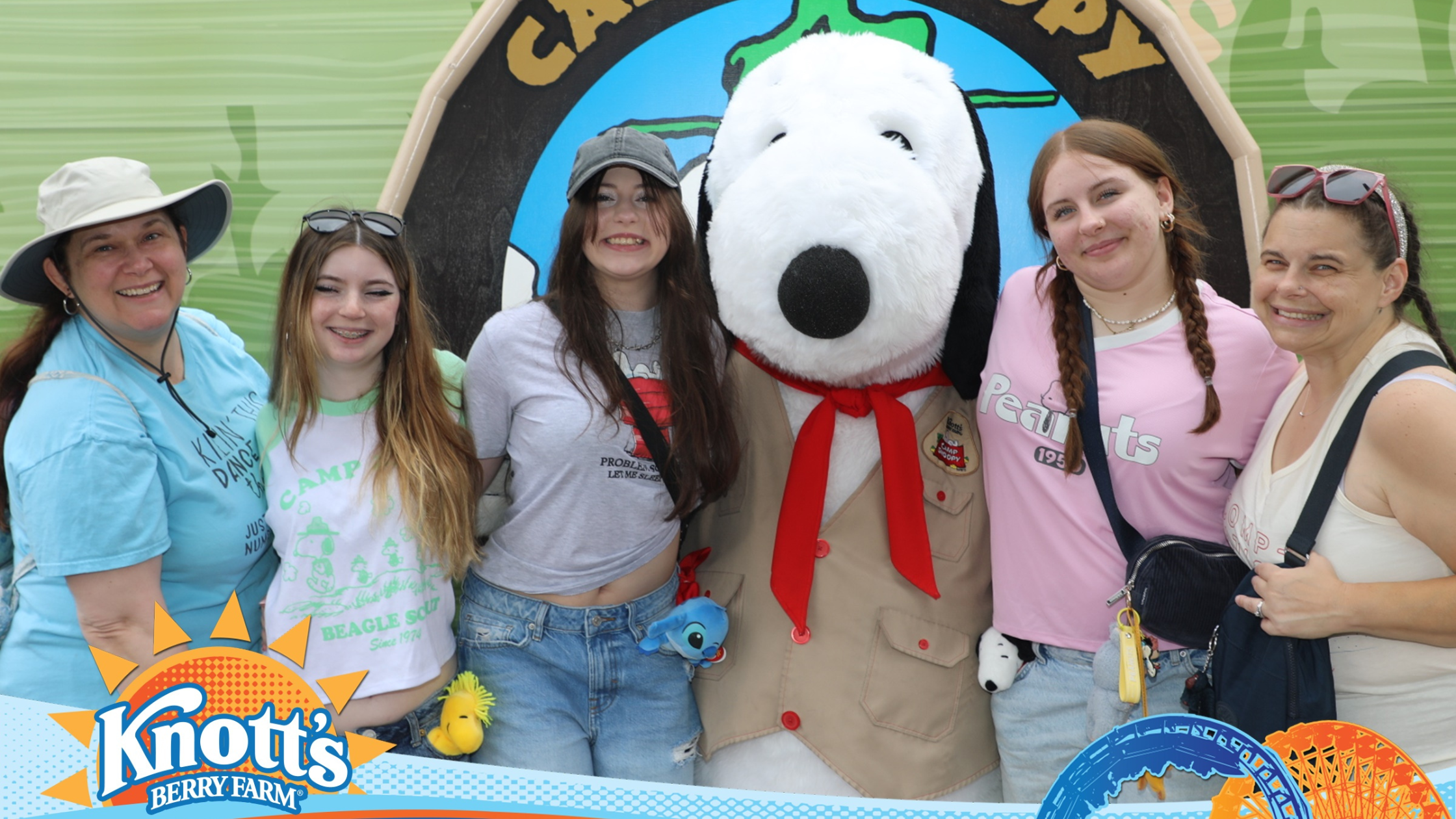 Dance moms and dancers posing with Snoopy at Knott’s Berry Farm in Anaheim California during a competition trip, showing a fun and budget friendly theme park alternative to Disneyland.