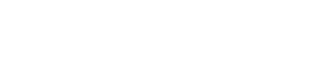 A person working on a laptop at a desk in a modern, well-lit office.