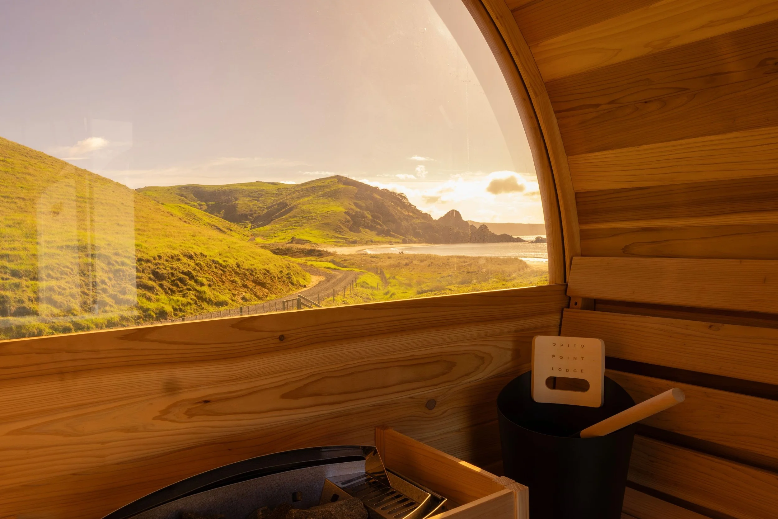 View from inside the Sauna looking over the green hills beside Opito Point Lodge - Luxury Accommodation in Coromandel, New Zealand