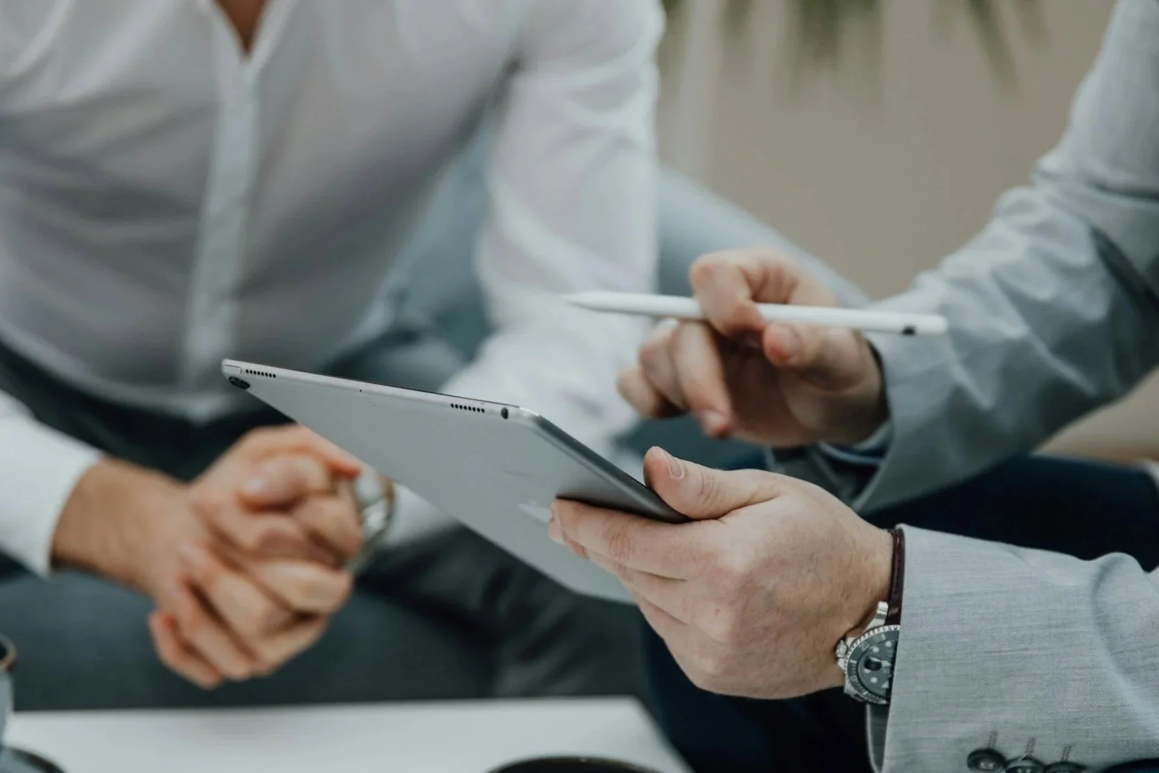 Two people reviewing a document together at a table, one holding a pen and the other holding the paper.