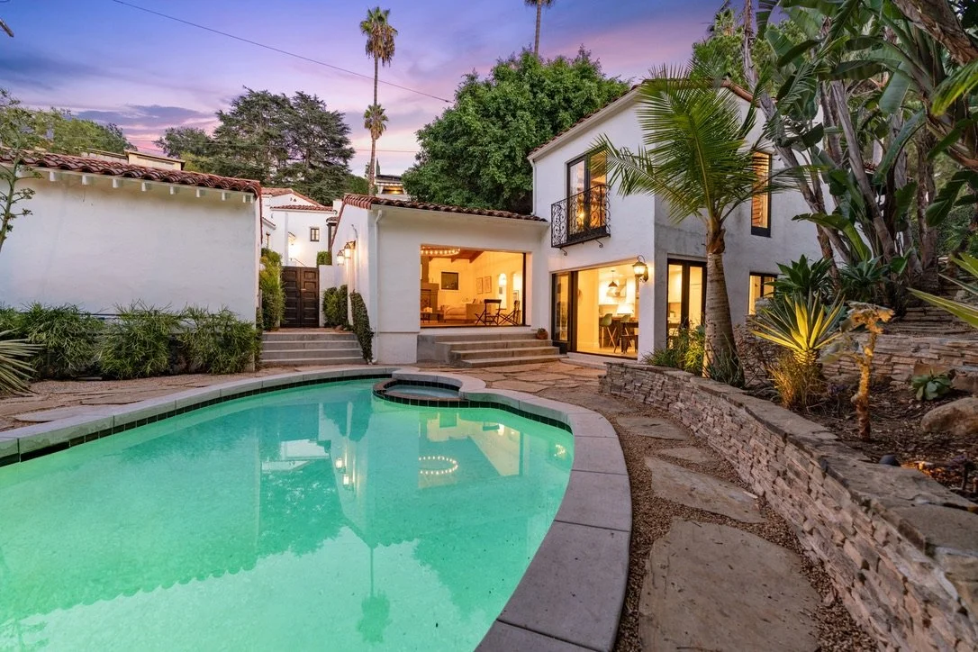 Presented by Missig Team, a real estate team at Berkshire Hathaway HomeServices California Properties in Beverly Hills and Los Angeles. This Spanish celebrity owned home is in the Hollywood Hills. A backyard with a swimming pool surrounded by stone a