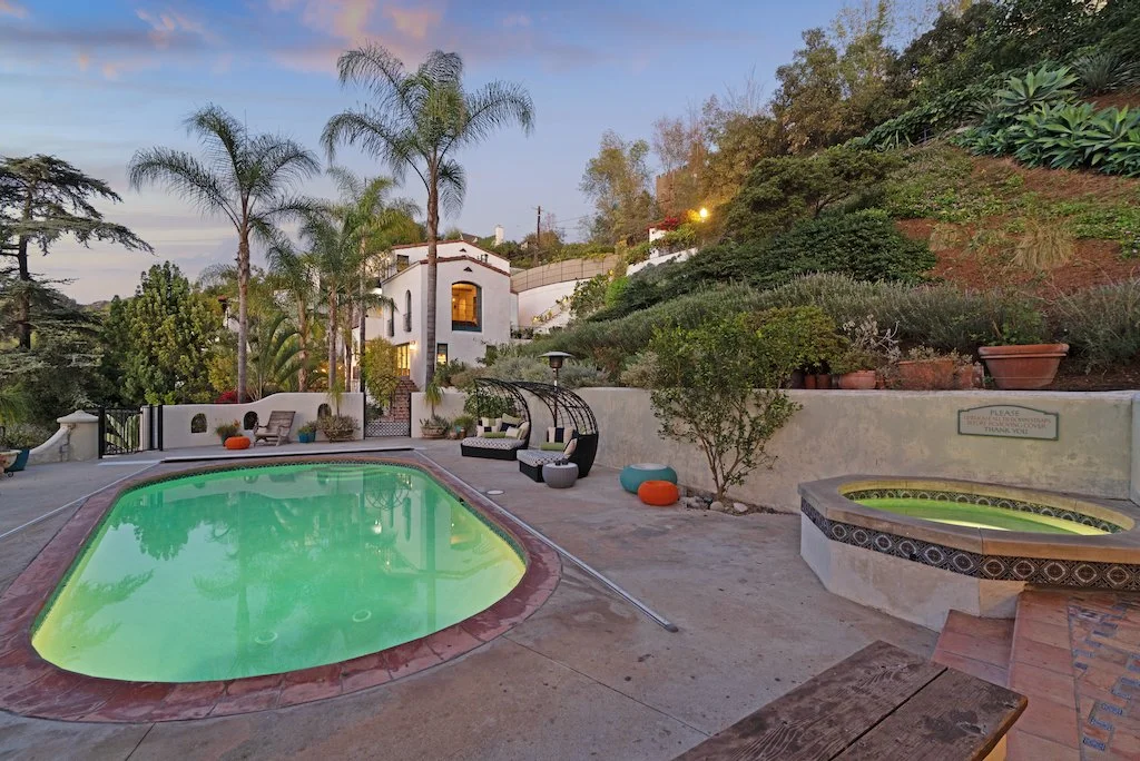Presented by Missig Team, a real estate team at Berkshire Hathaway HomeServices California Properties in Beverly Hills and Los Angeles. A Spanish estate hillside property in the Hollywood Hills. A swimming pool and hot tub, surrounded by lush greener