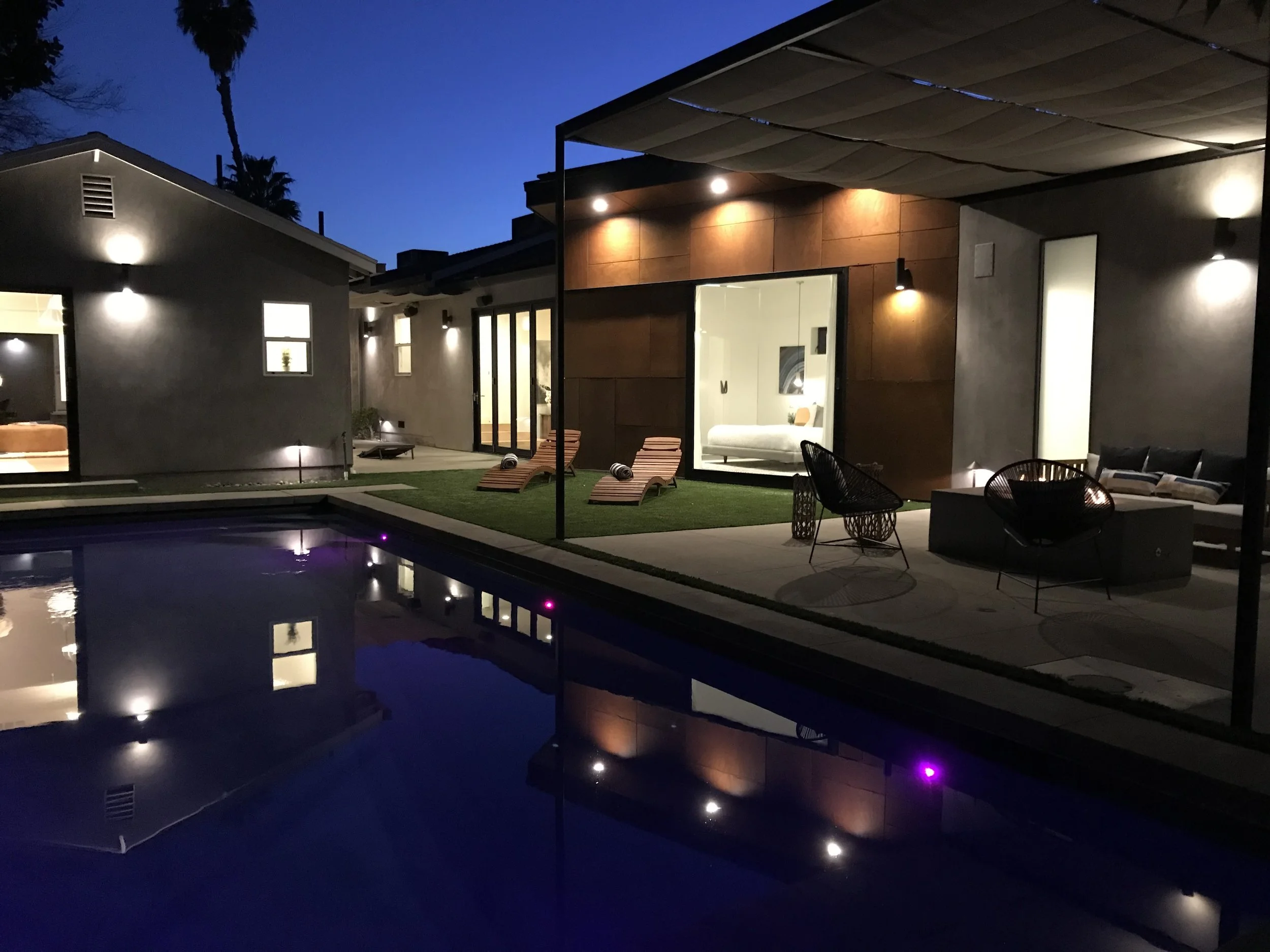 Modern eco-friendly smart home in Toluca Lake featuring 4 bedrooms, 4 bathrooms, an office, and a large guest house. Designed for indoor-outdoor living with Fleetwood sliding glass walls, pool, fire pit, outdoor kitchen, and dining area. Includes a g