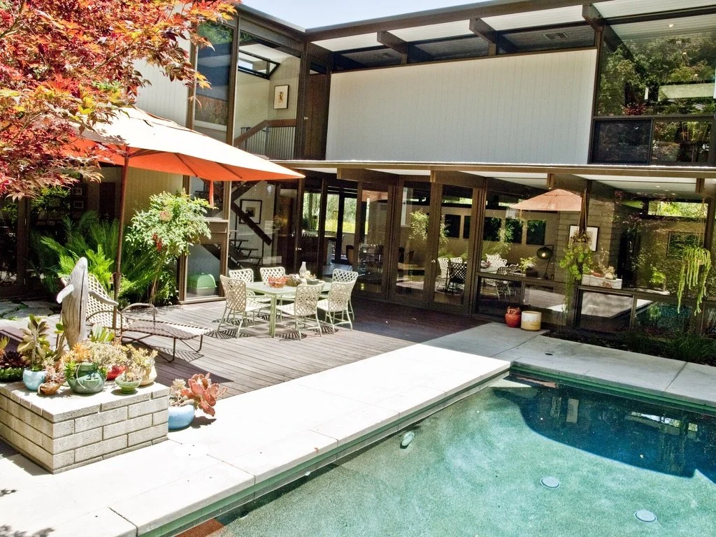 Presented by Missig Team, a real estate team at Berkshire Hathaway HomeServices California Properties in Beverly Hills and Los Angeles. A 2-story architectural home by Calvin Straub AIA. The backyard area with a swimming pool, a patio with a dining t