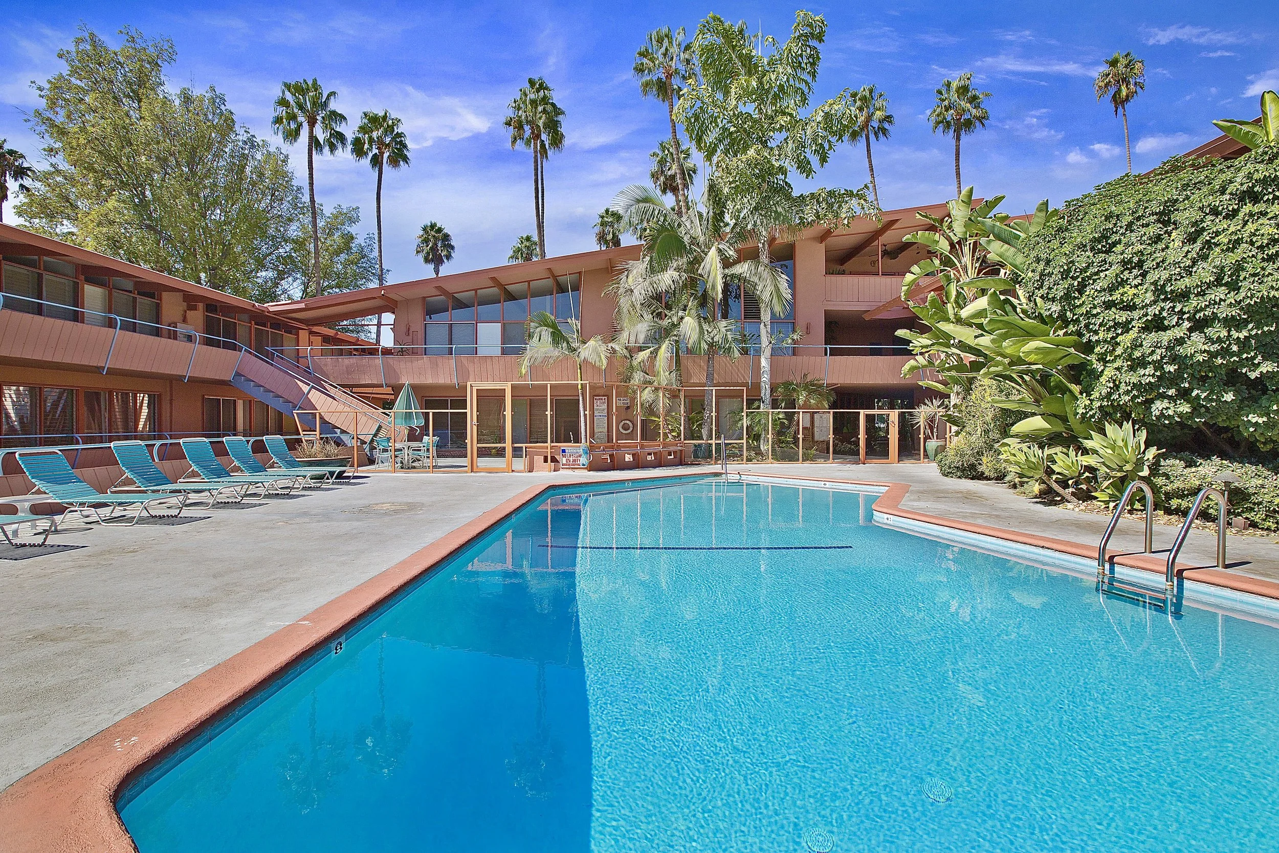 The Hollywood Riviera, a historically designated 1953 building in West Hollywood designed by architect Edward Fickett FAIA. A classic example of mid-century California architecture, featuring a central courtyard with pool, surrounded by palm trees an