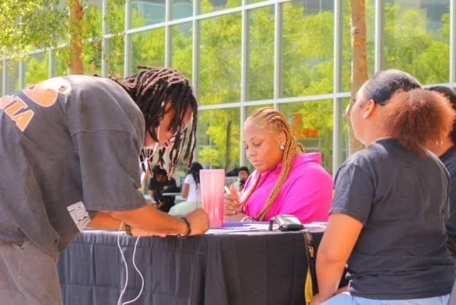 College students registering to vote at Donuts and Democracy table.