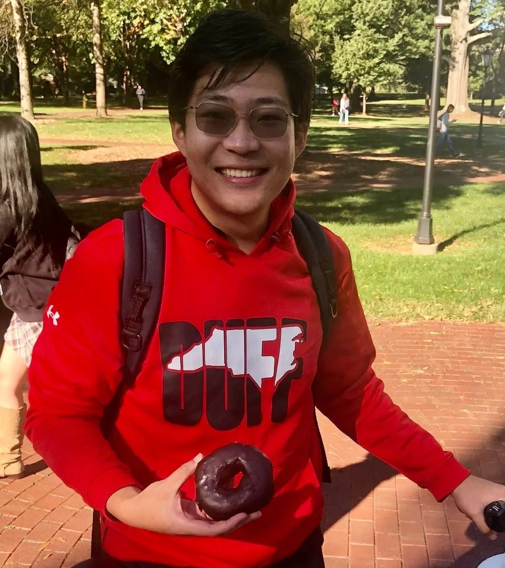 College student with donut at Donuts and Democracy table.