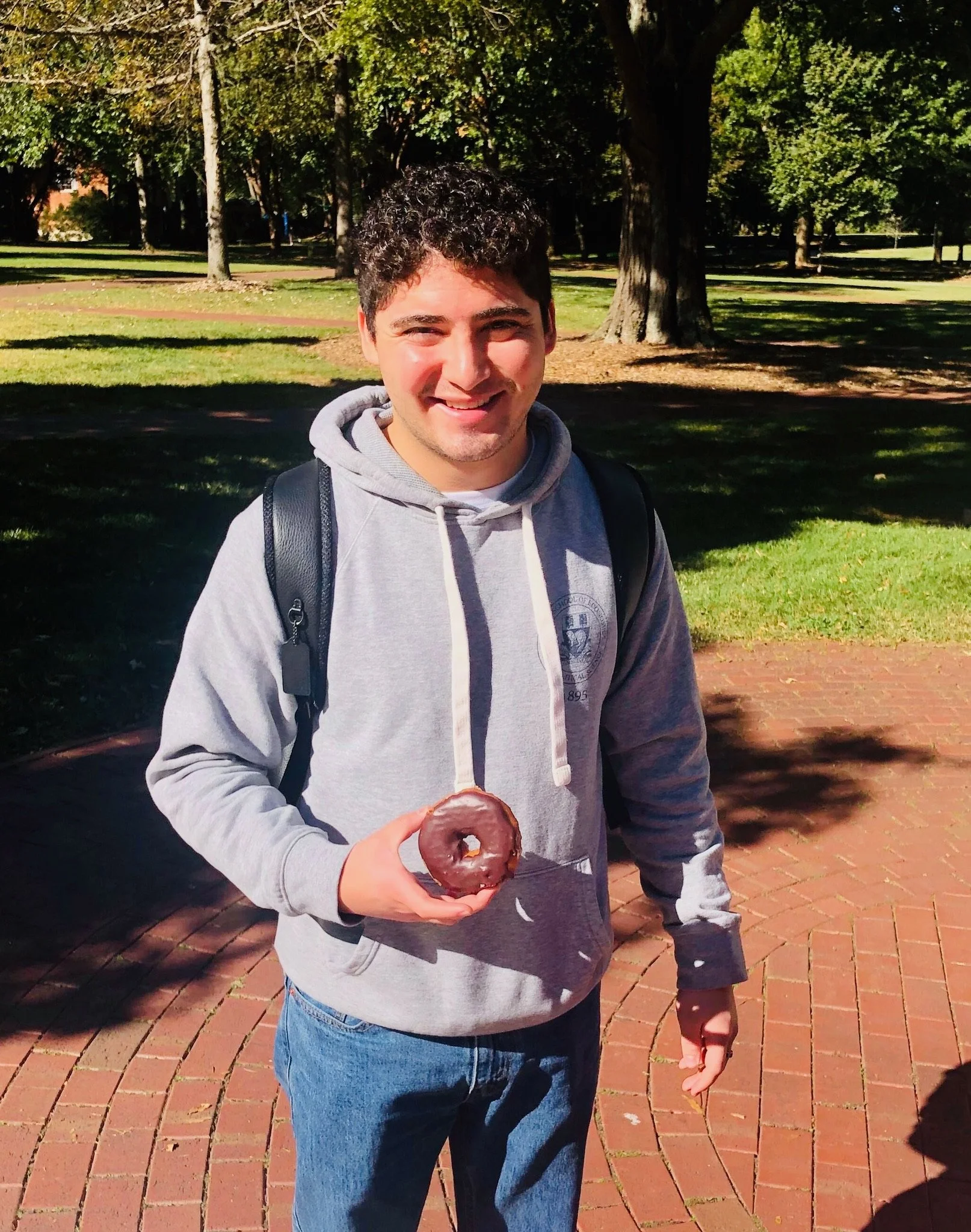 College student with donut at Donuts and Democracy table.
