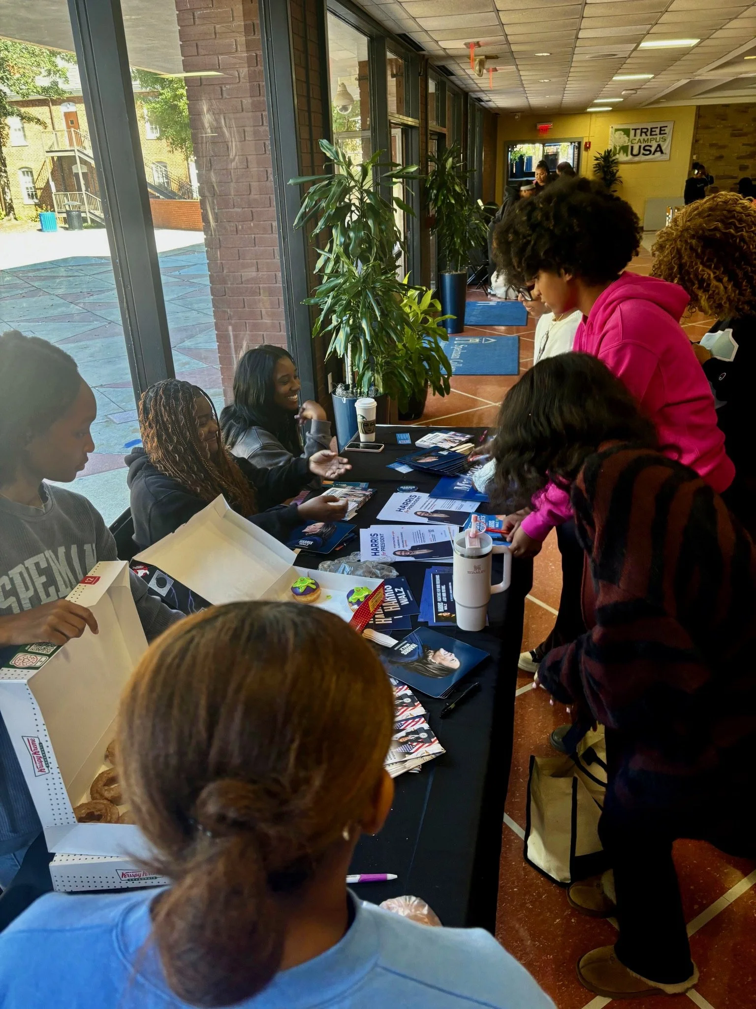 College students registering to vote at Donuts and Democracy table.