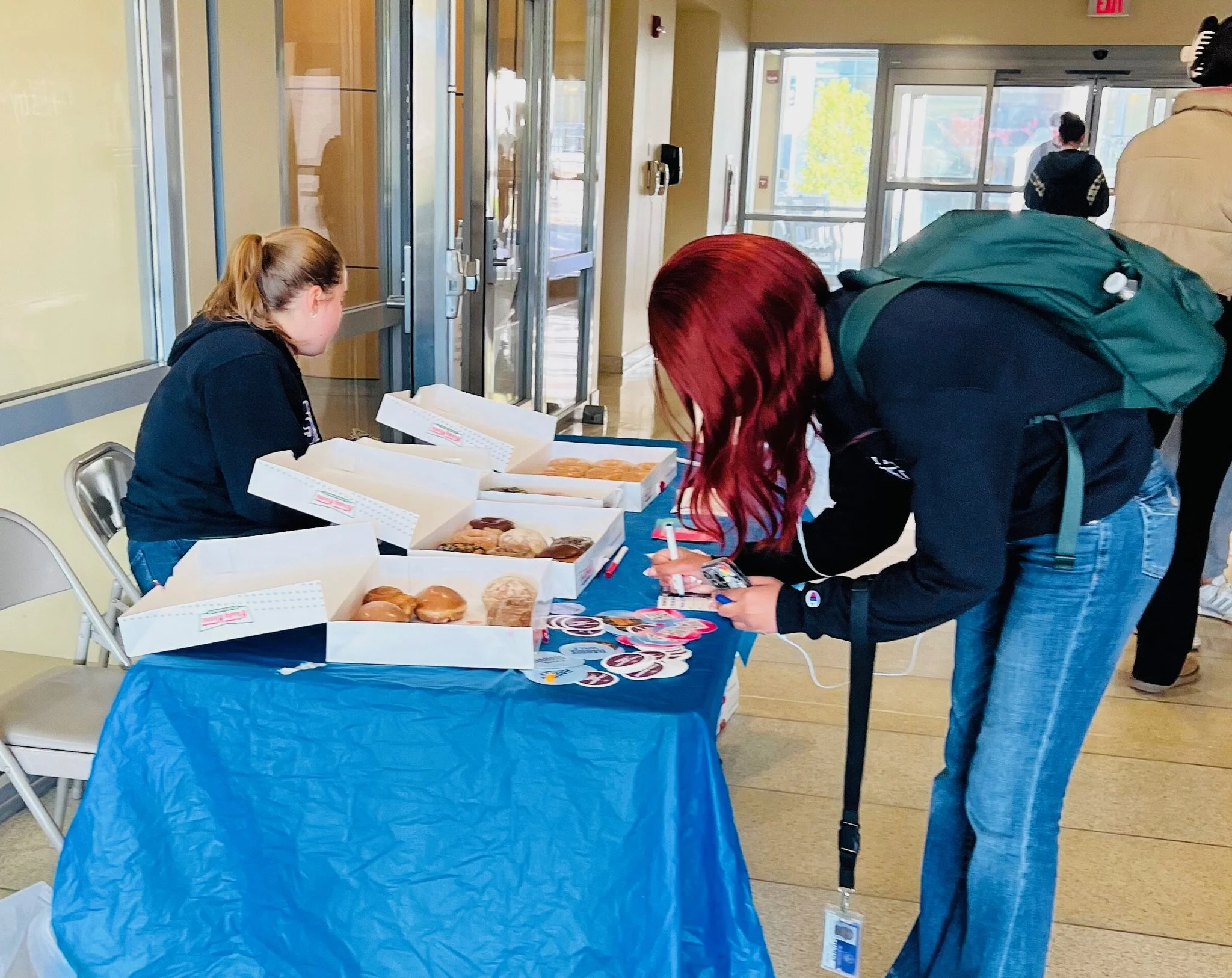 College students registering to vote at Donuts and Democracy table.
