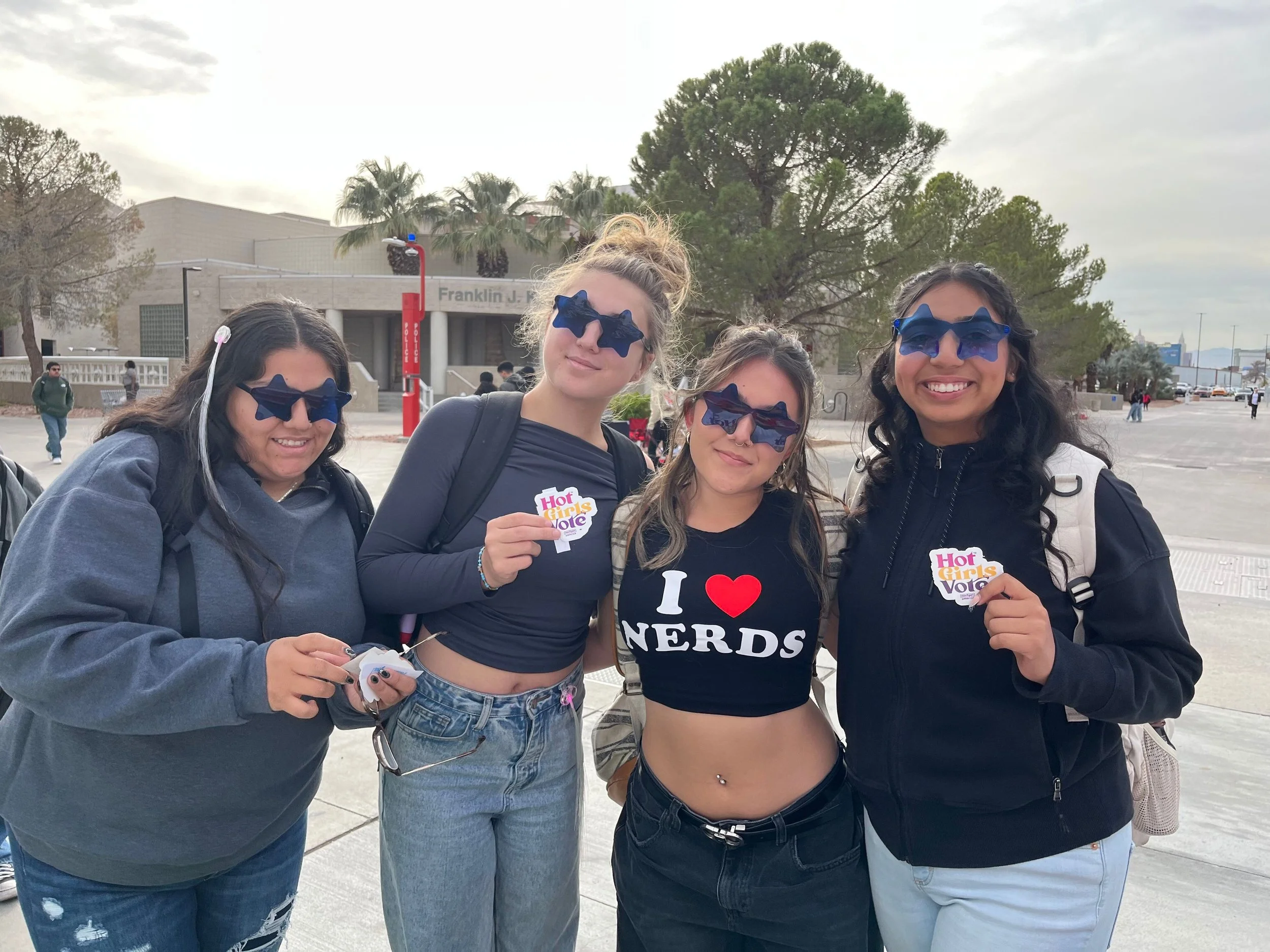 Four women holding Hot Girls Vote stickers at UNLV.