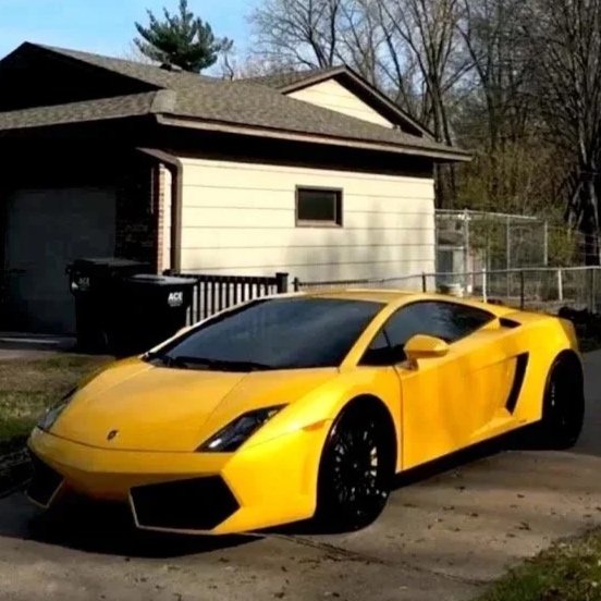 Yellow Lamborghini sports car parked in front of a house.