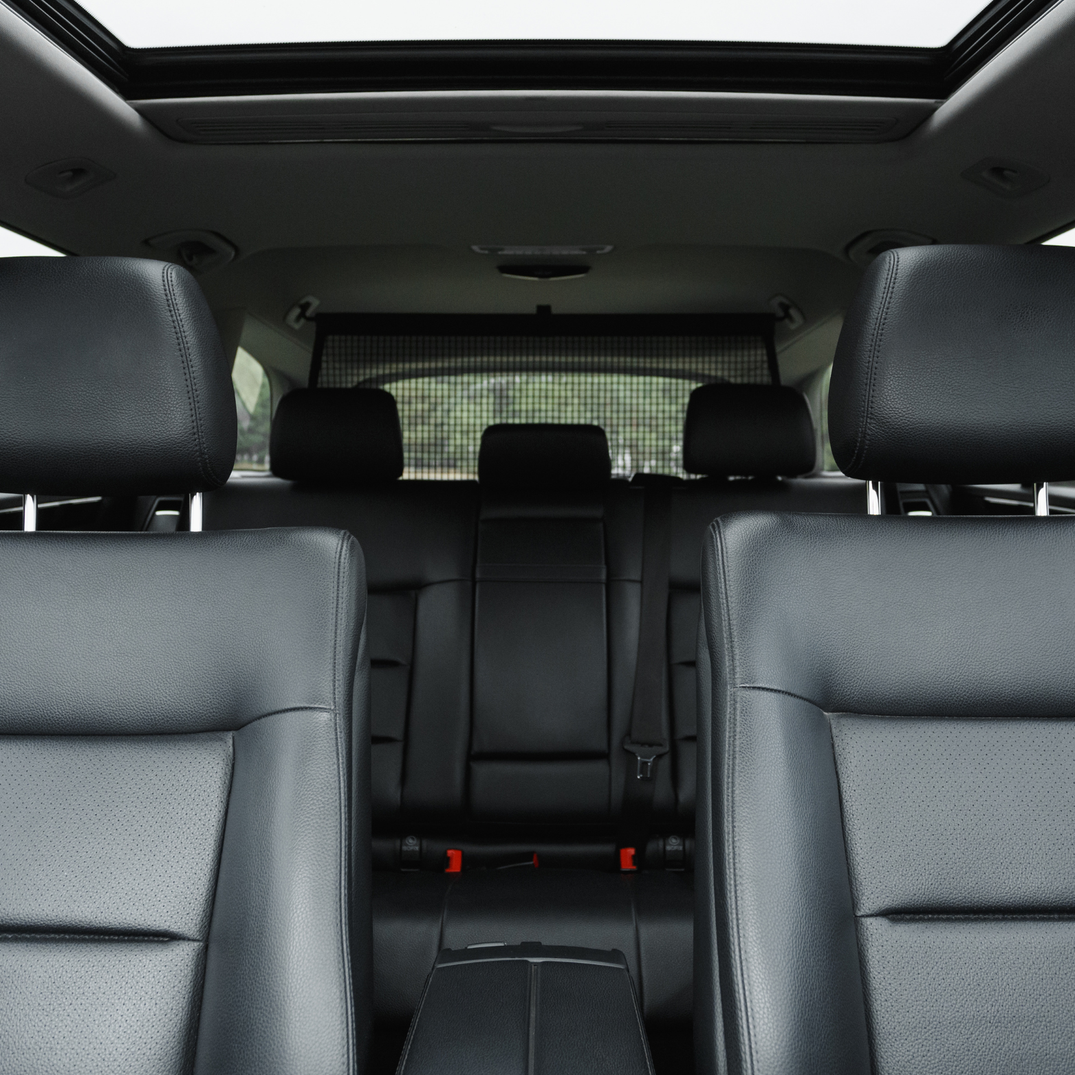 Interior view of a modern SUV with black leather seats, three rows of seating, and a sunroof.