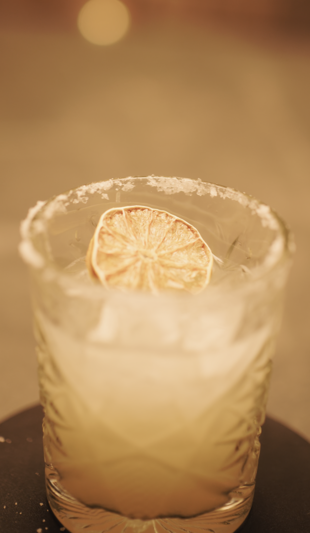 Verre contenant une boisson avec une tranche de citron citronnée flottant dessus, décoré avec du sel ou du sucre sur le rebord