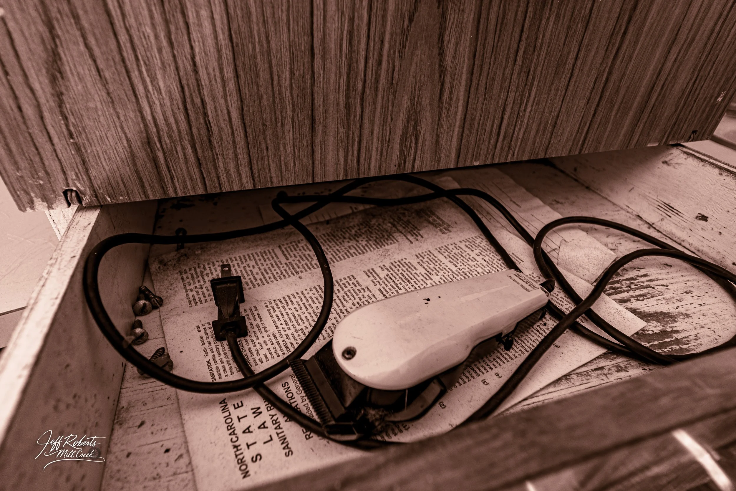Electrical cords and a power adapter placed on a newspaper inside a drawer.