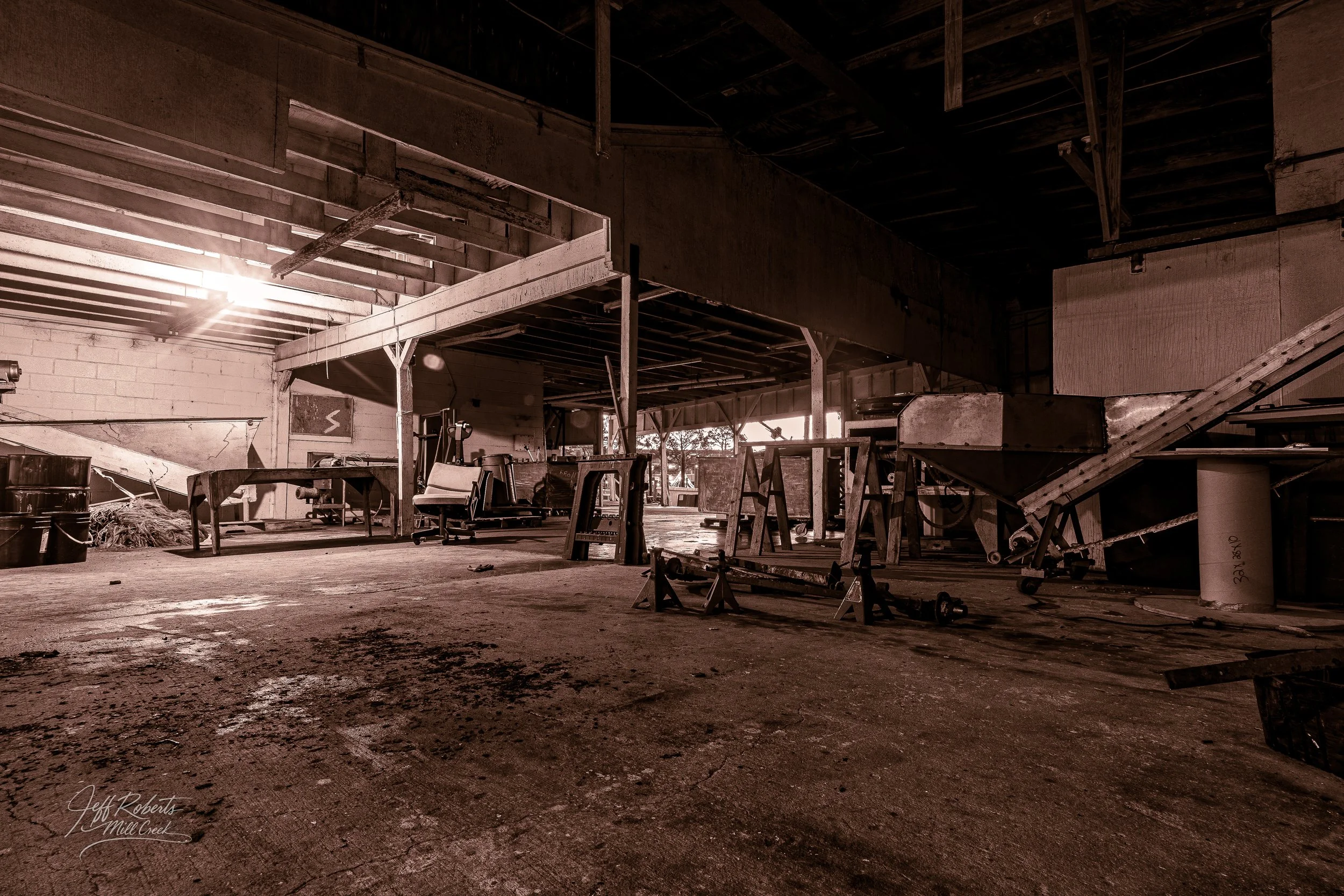Interior of an unfinished or abandoned building with construction equipment, debris, and exposed structural elements.