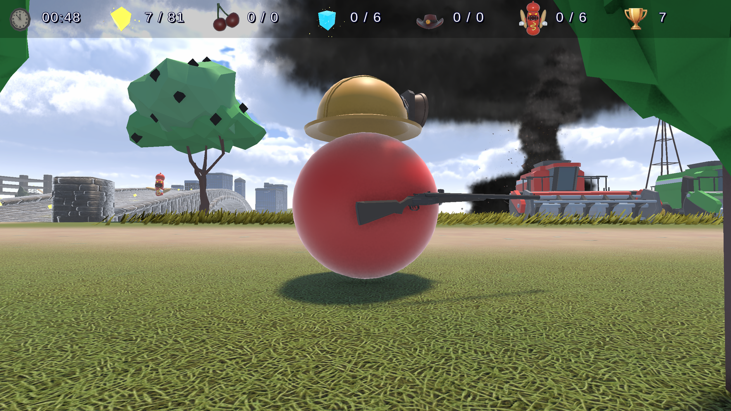 A scene from a video game showing a polygonal character wearing a helmet with a gun attached, sitting on a large red sphere. There is a tree, a fence, and buildings in the background, along with black smoke and a tank. The game interface displays at the top with icons, counters, and a timer.