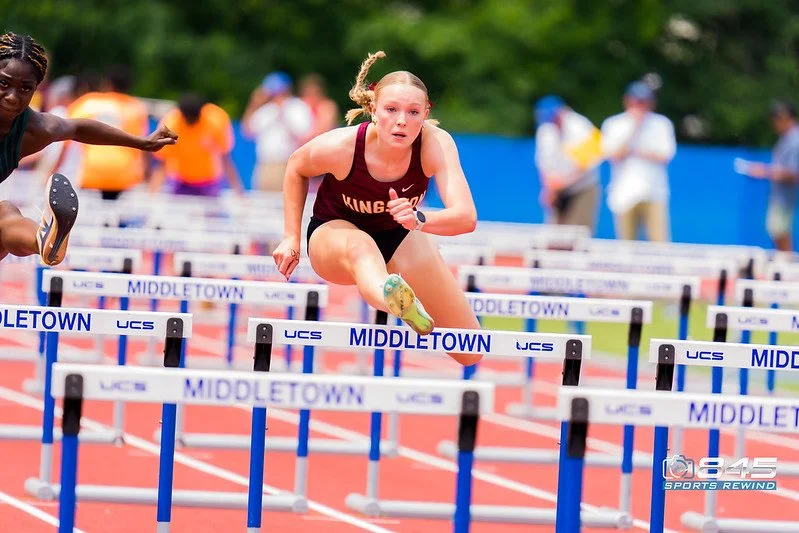 Kingston High School track athlete competes at nys track and field championship with blonde hair jumping hurdles at Middletown high school