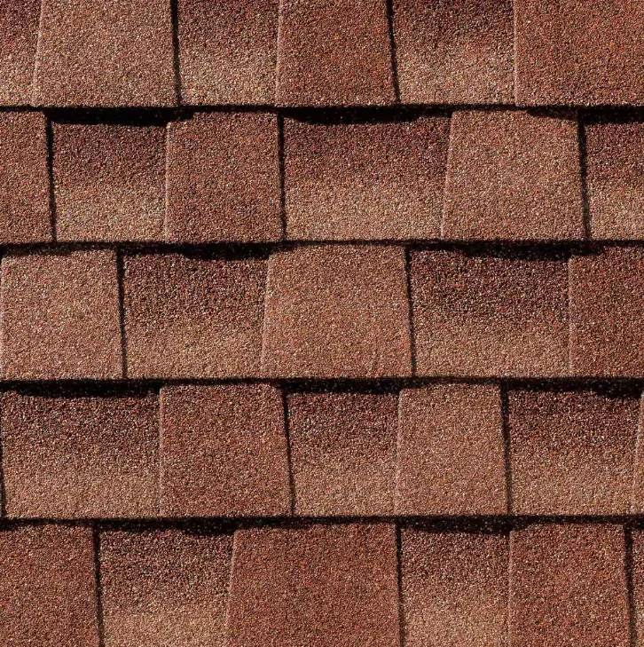 Close-up of a roof with multiple rows of reddish-brown asphalt shingles.