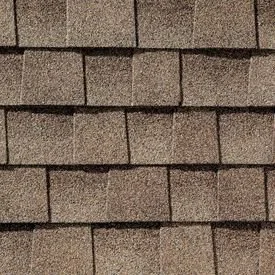 Close-up of a section of a shingled roof with overlapping brown shingles.