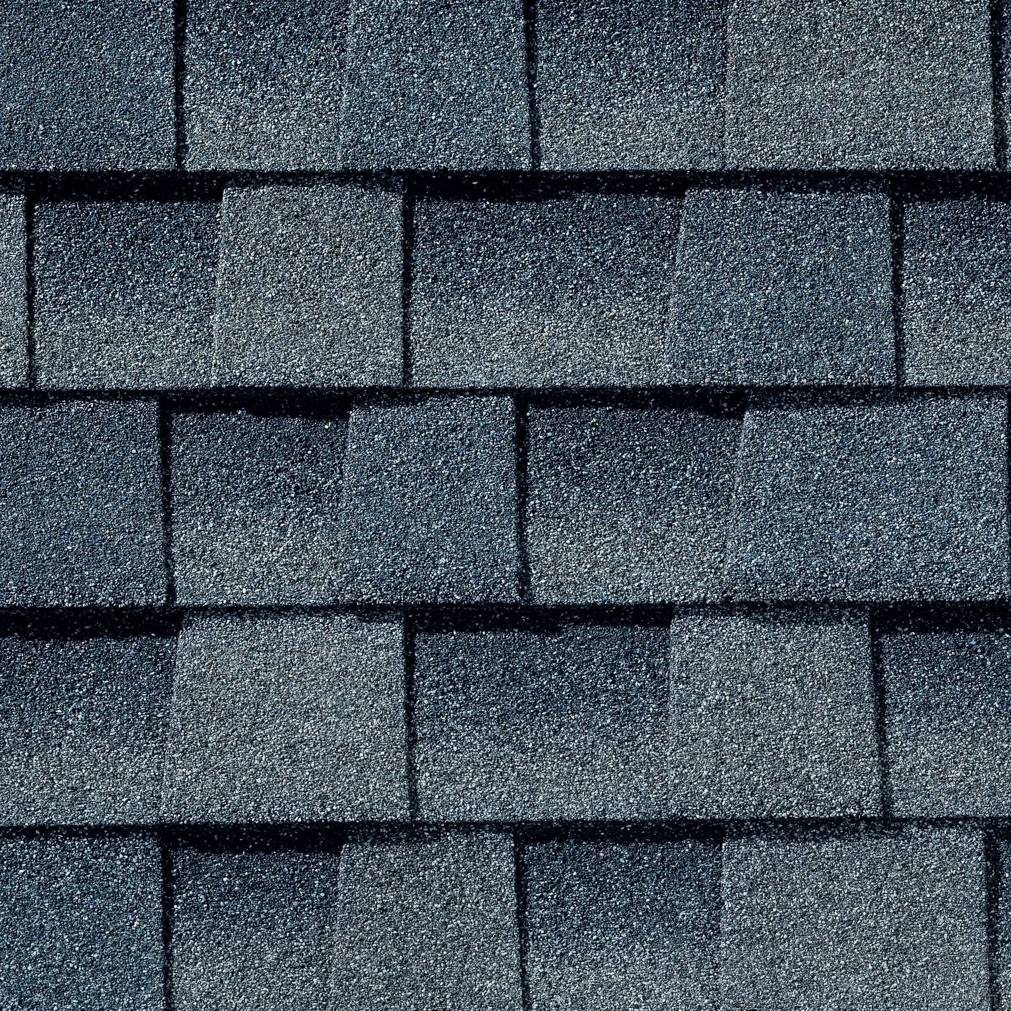 Close-up view of asphalt shingles on a roof, showing texture and layering.