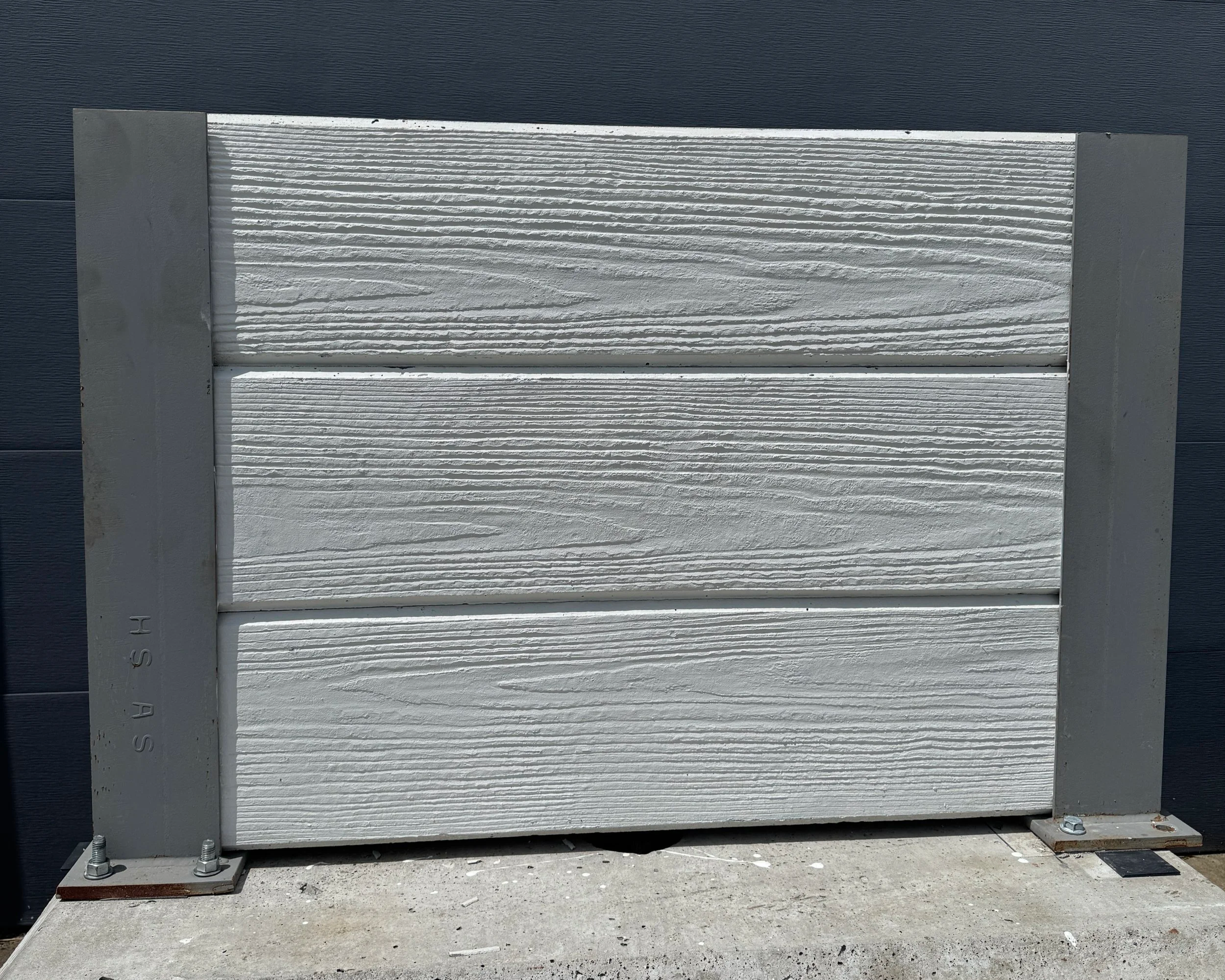 A front-facing photo of a precast concrete fence.