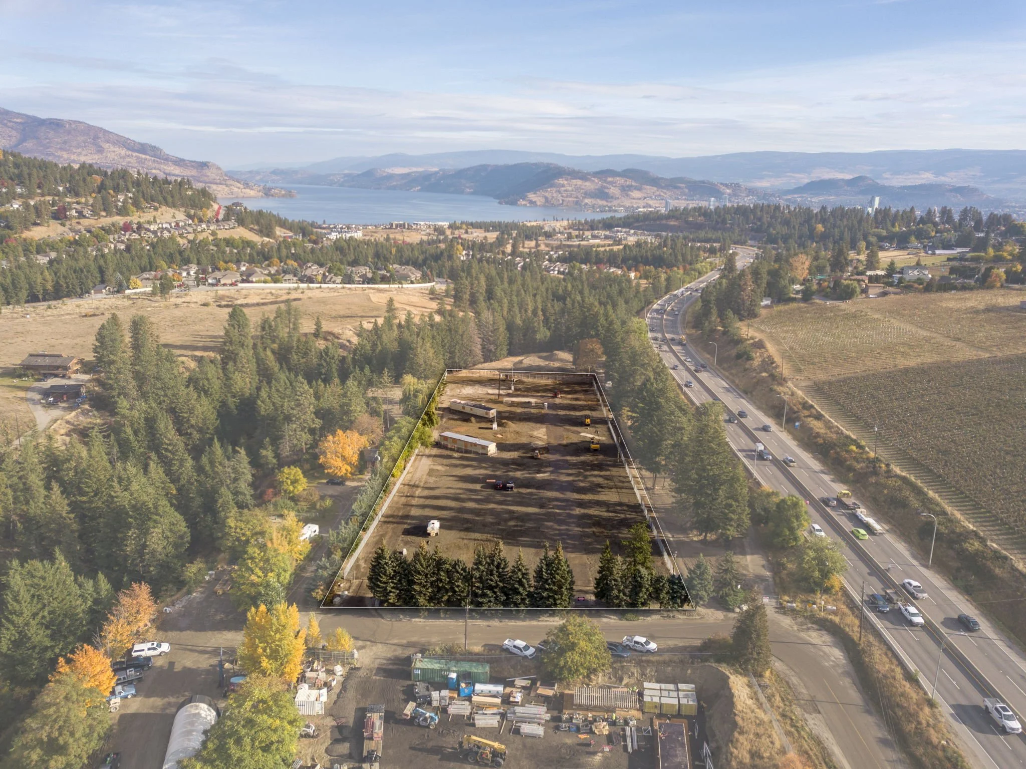 Photo of a boat and RV parking lot in West Kelowna with Lake Okanagan and Highway 97 in the background.