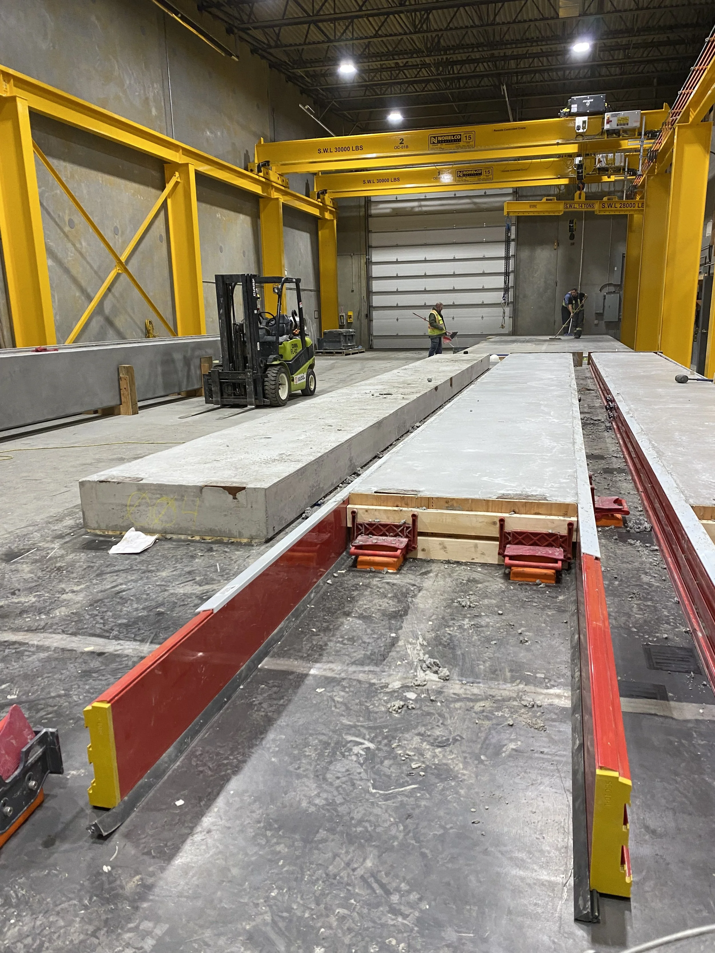 Inside view of a precast manufacturing warehouse with large concrete slabs on the floor.