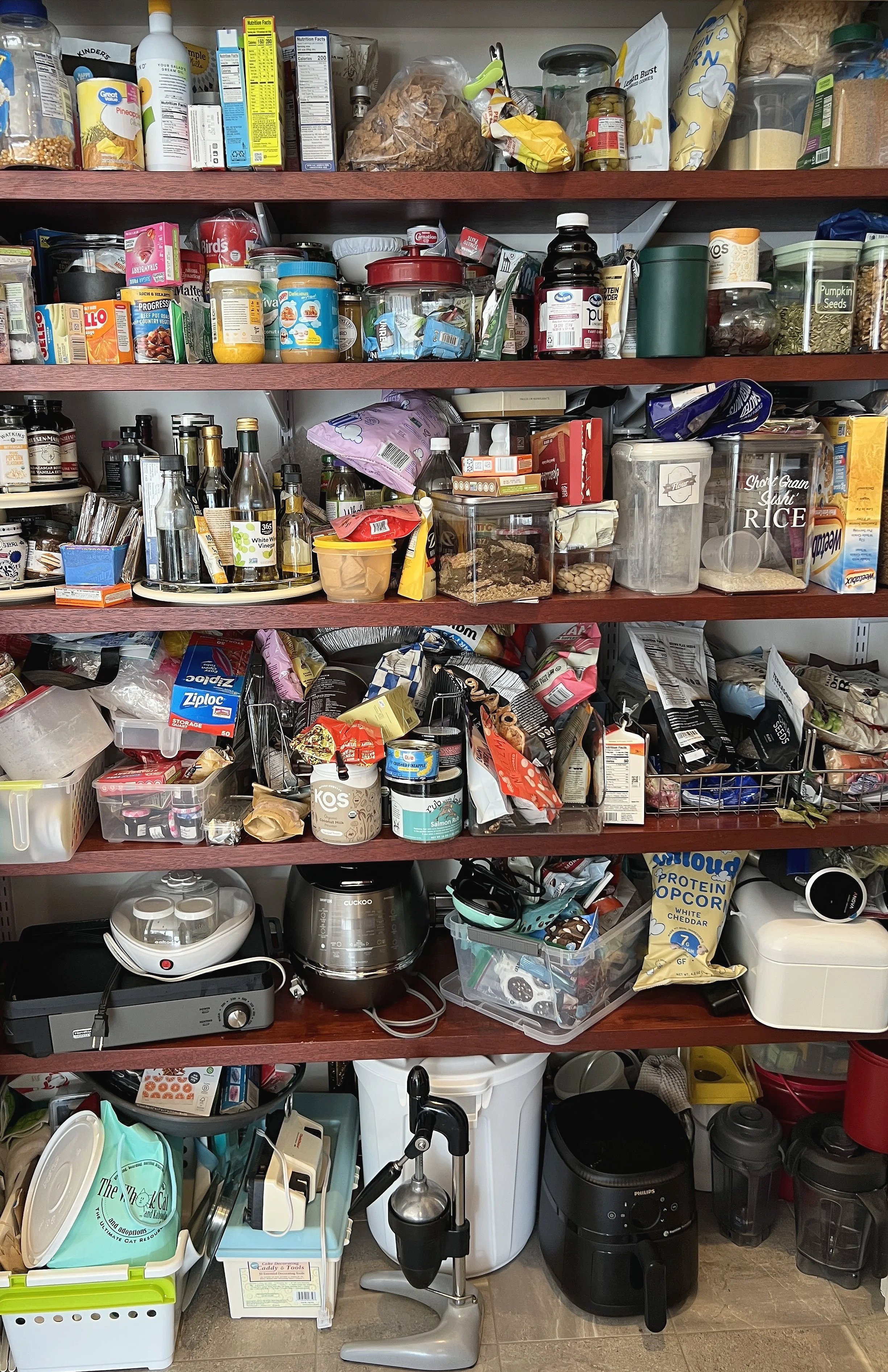 Crowded pantry shelves before professional organizing