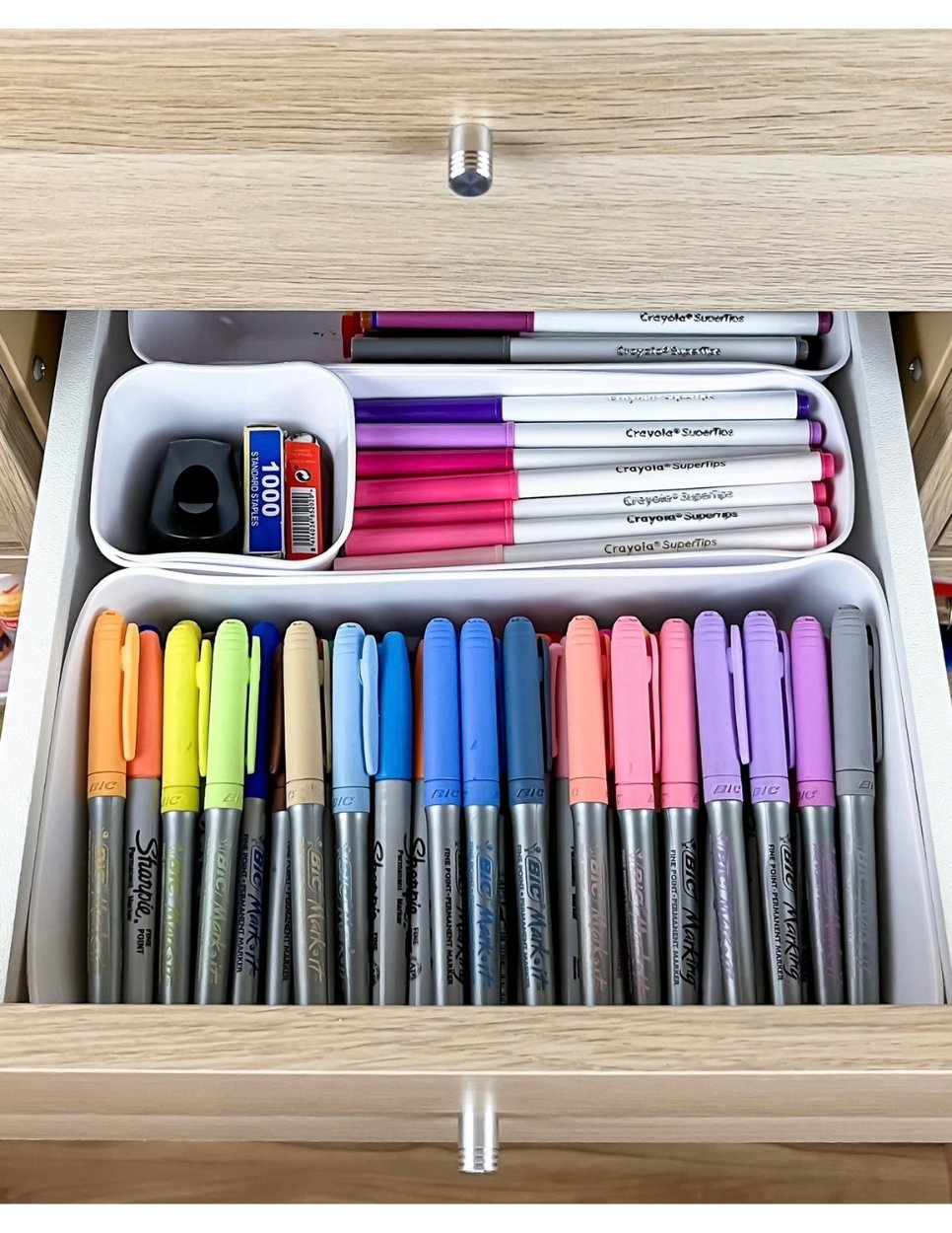 Organized drawer with markers and small supplies sorted into compartments