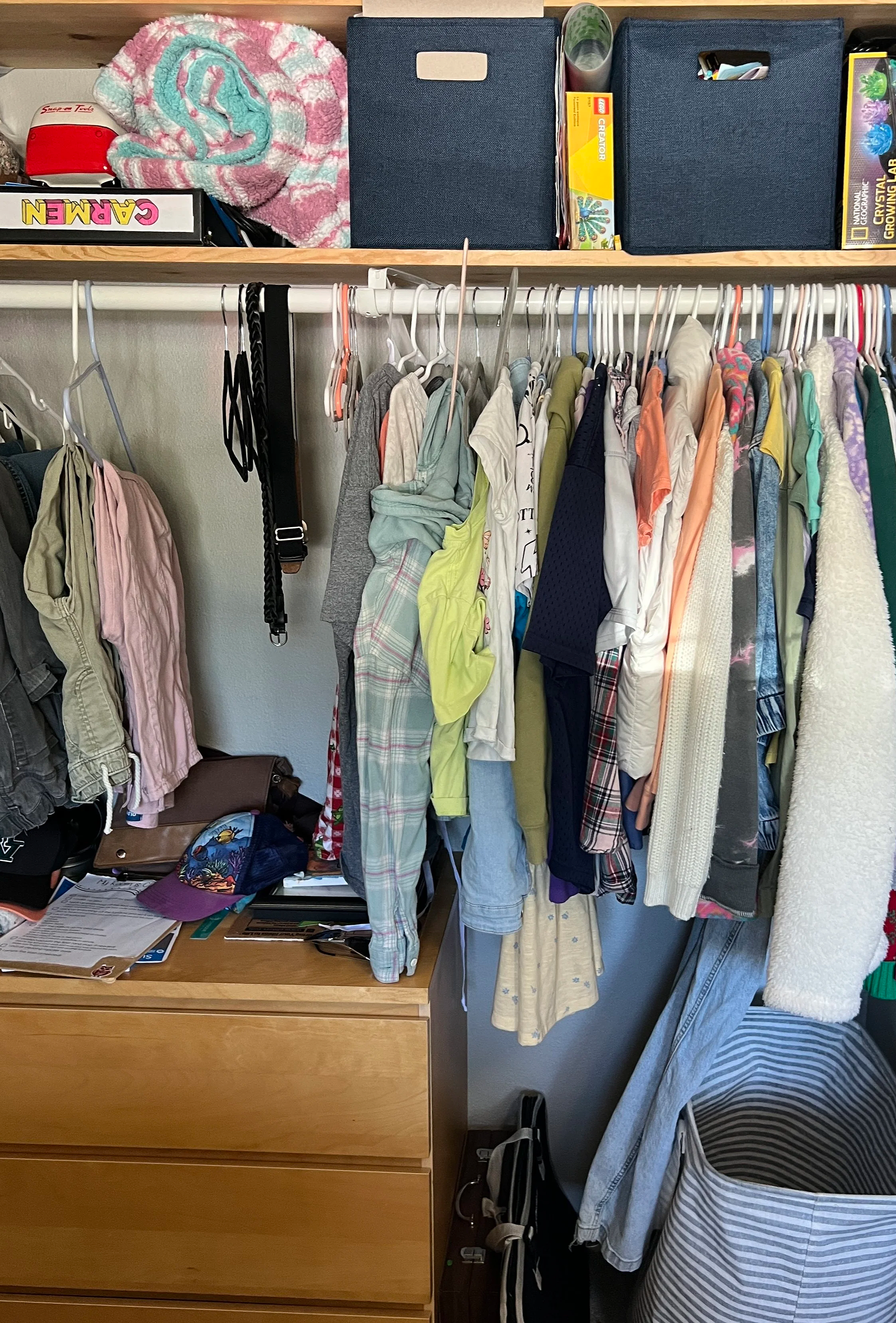 Crowded clothing closet before professional organizing