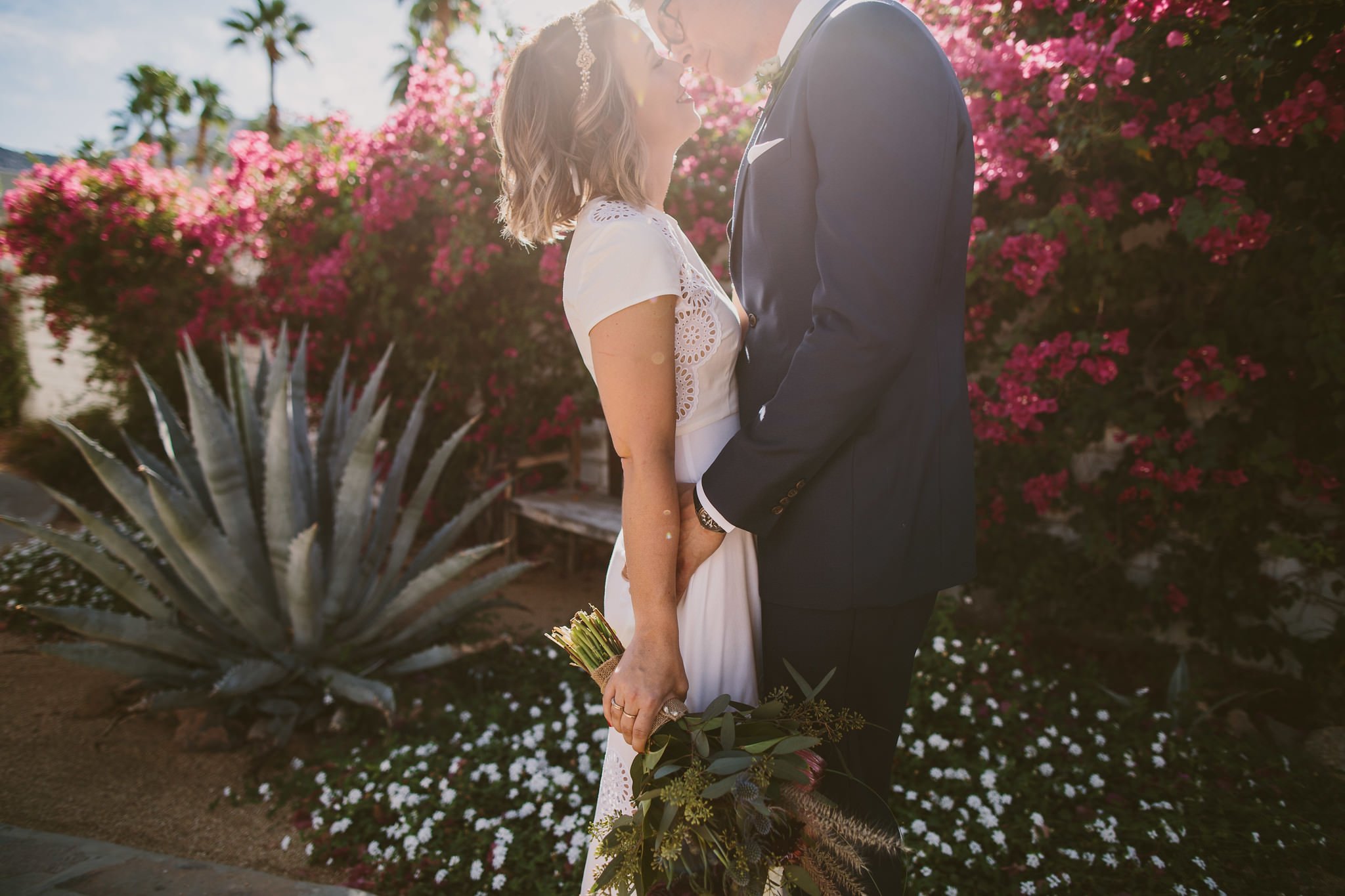 Couple embracing with Palm Springs desert plants behind them- -DESTINATION Fine Art Wedding Photographer
