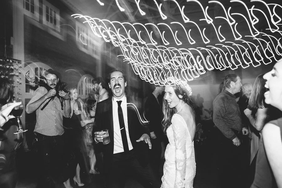 Candid photo of a bride and groom partying at their wedding reception