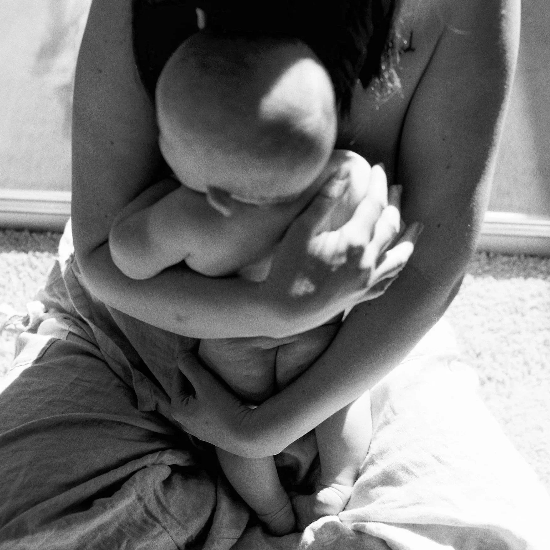 A black and white film image of a mother holding her baby