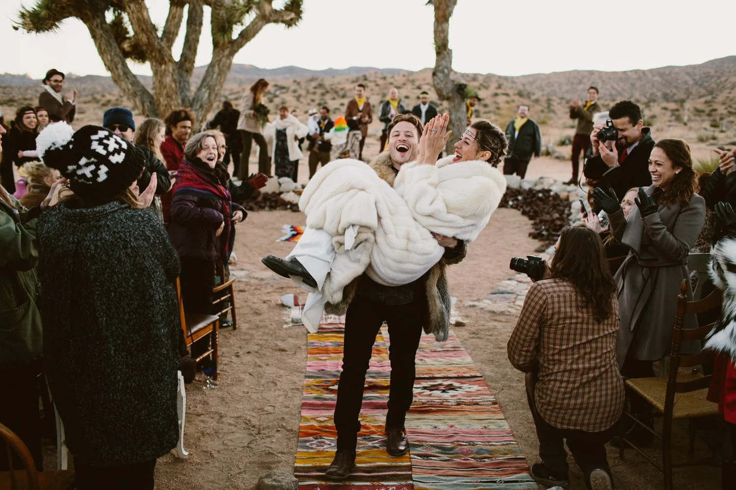 Eclectic Groom carries bride down the aisle in Joshua Tree- Destination Fine Art Wedding Photographer