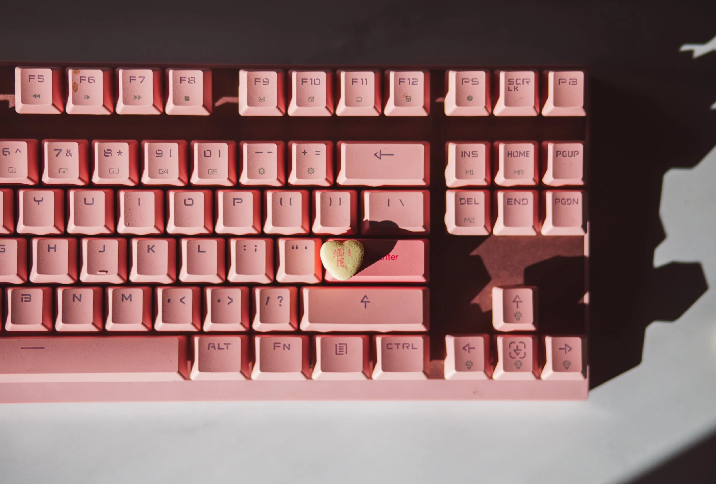 a pink keyboard with a candy heart on top