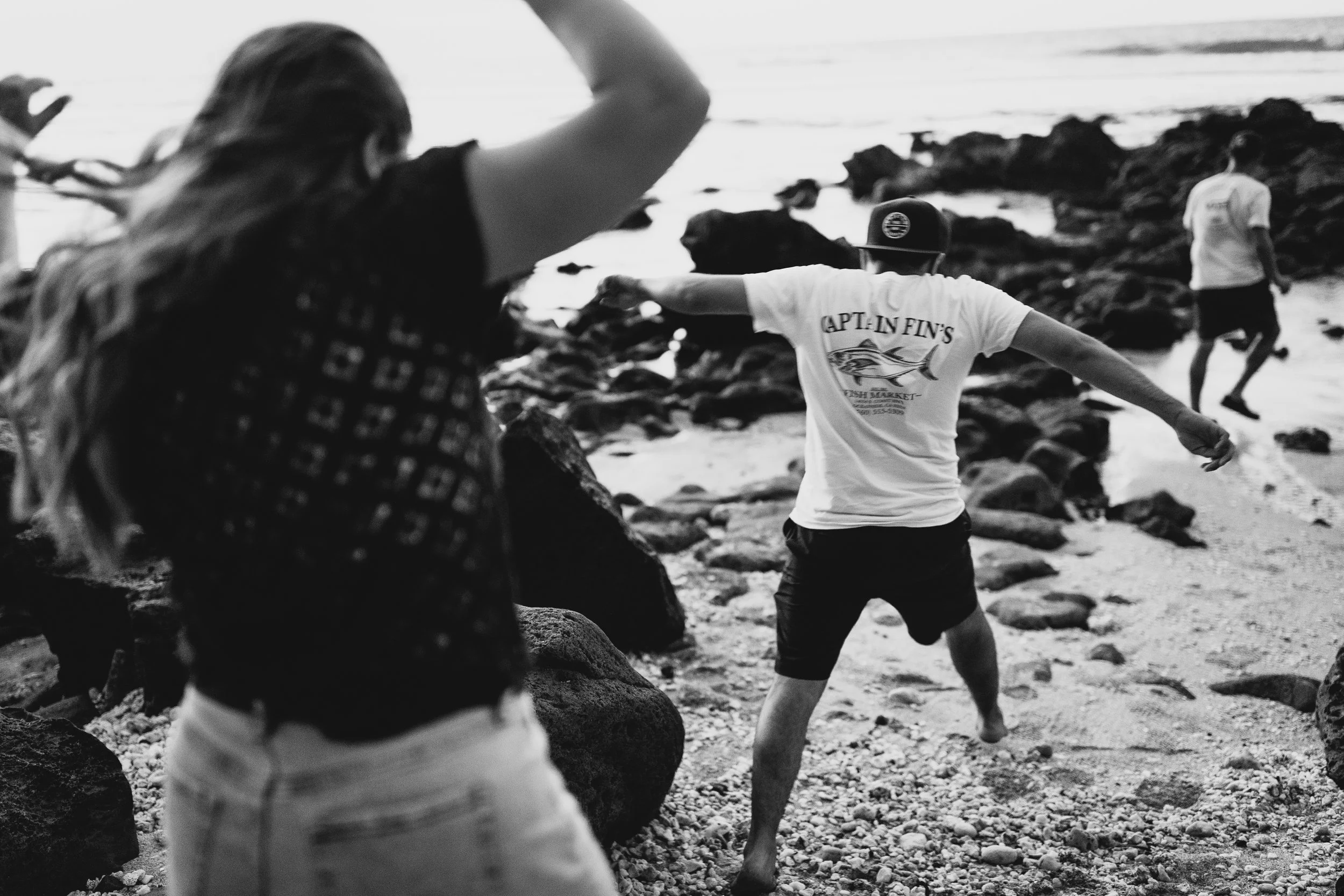 People playing catch on a rocky beach in Maui, Hawaii