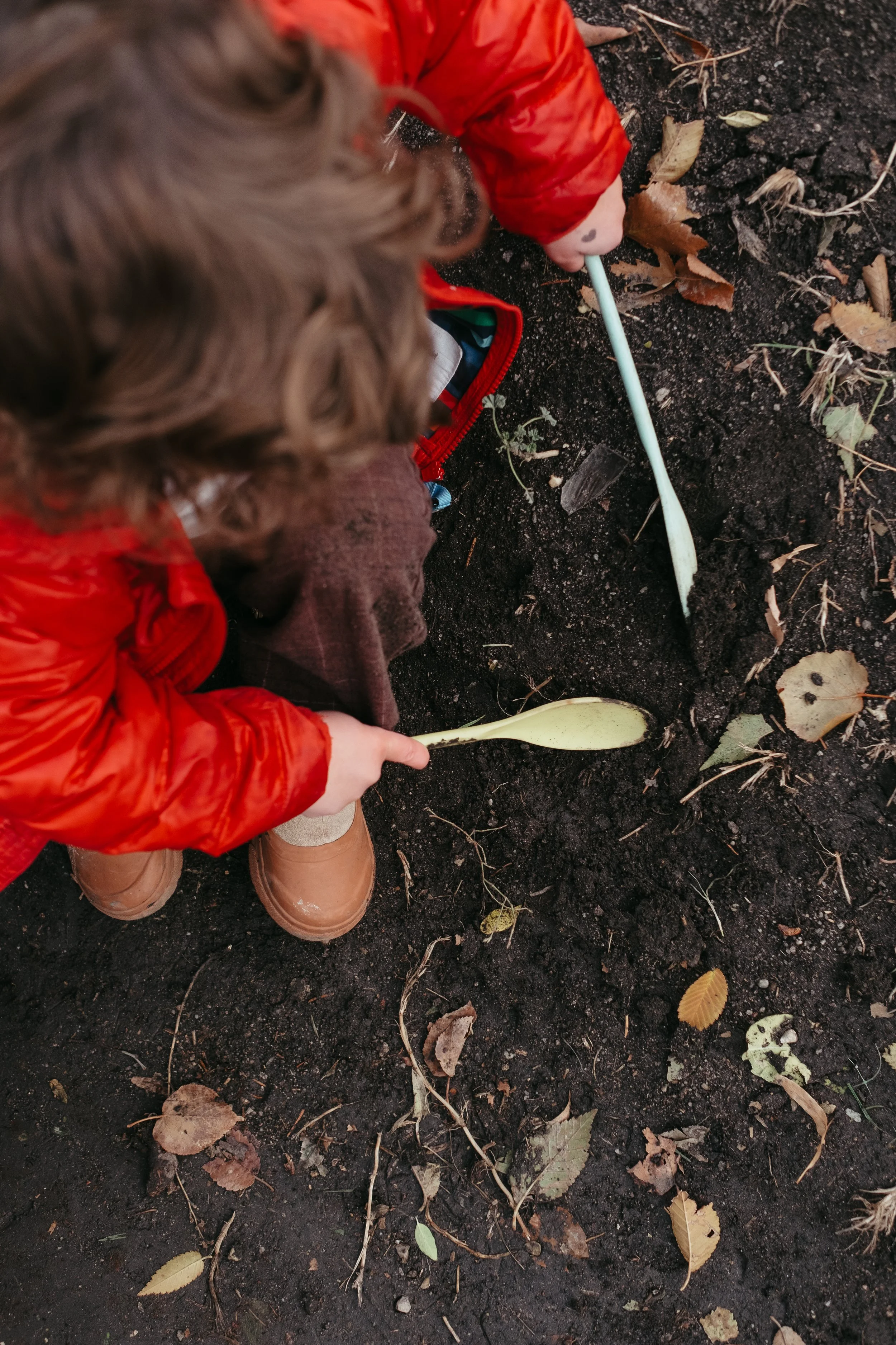 Preschool teacher showing child how to water a garden