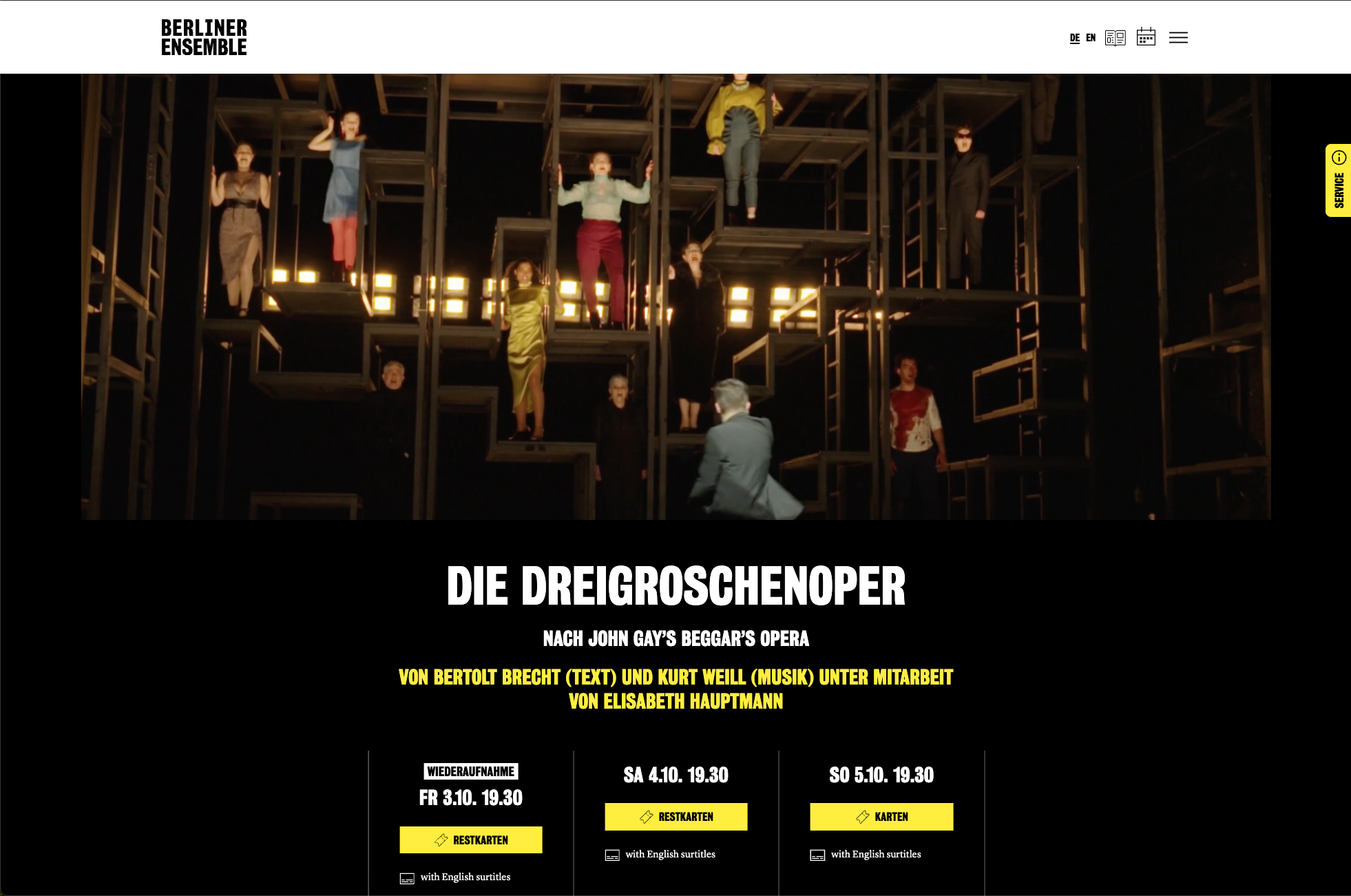 Webseite der Berliner Ensemble Theaters mit einem Bild einer Inszenierung, in der mehrere Schauspieler auf einer komplexen schwarzer Holzstruktur stehen, die wie eine moderne Skulptur wirkt.