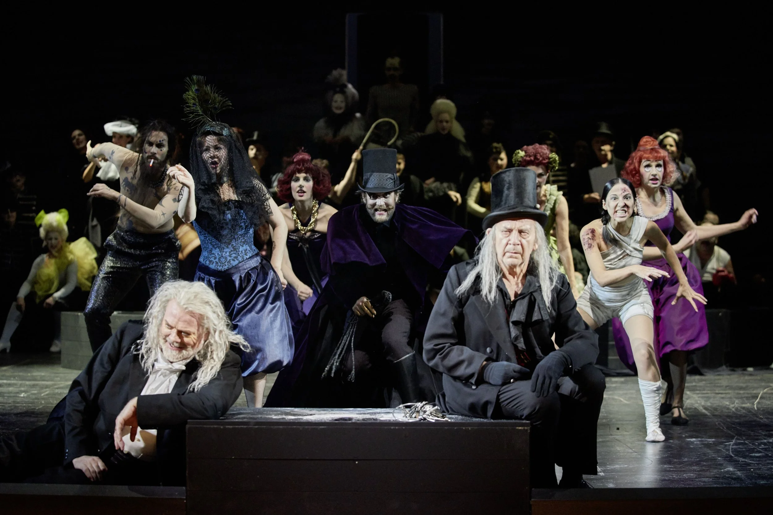 Schauspieler auf einer Bühne in bunter Kostümierung während einer Theateraufführung.