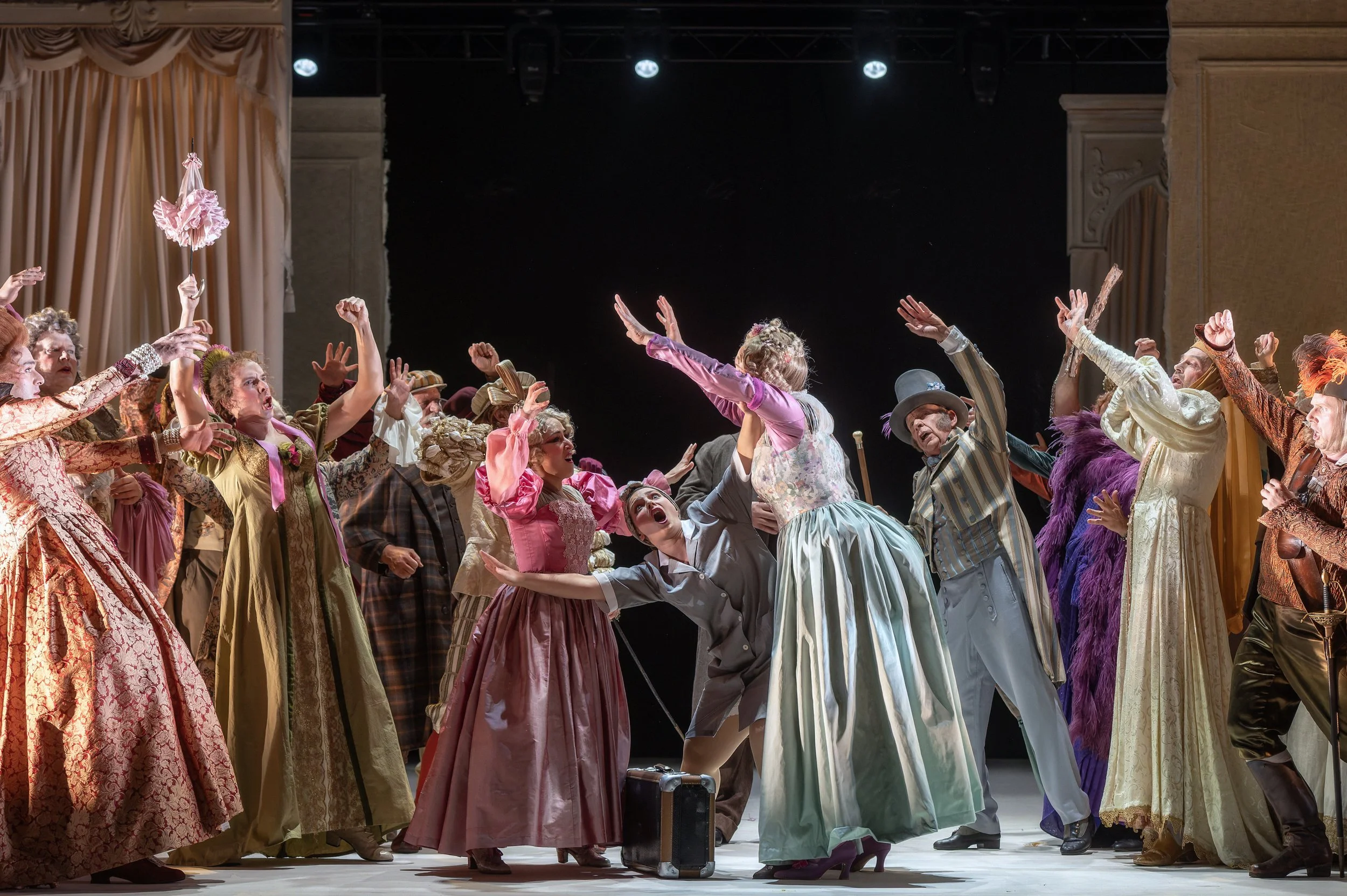 Bühnenbild einer Opern- oder Theateraufführung mit mehreren Darstellern in historischen Kostümen, die auf einer Bühne eine dramatische Szene inszenieren.