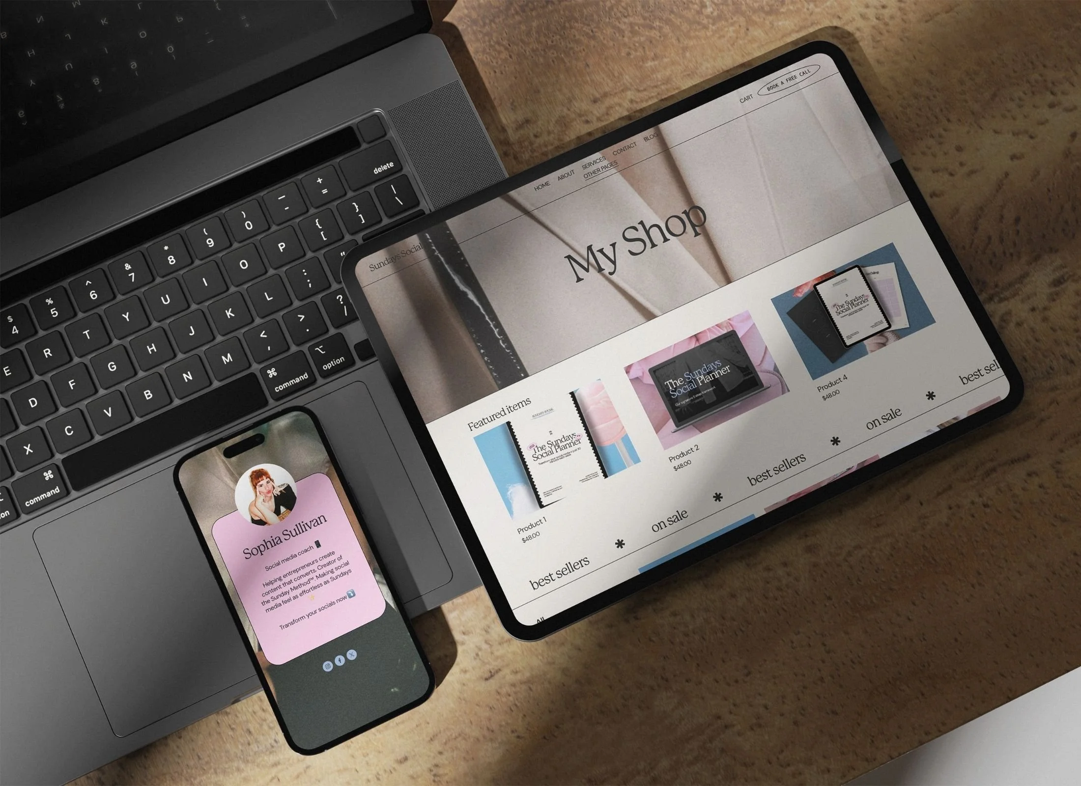 A laptop, a smartphone, and a tablet on a wooden surface. The laptop screen is not visible; the smartphone displays a profile of Sophia Sullivan, a social media coach. The tablet shows an online shop titled "My Shop" with various products listed.