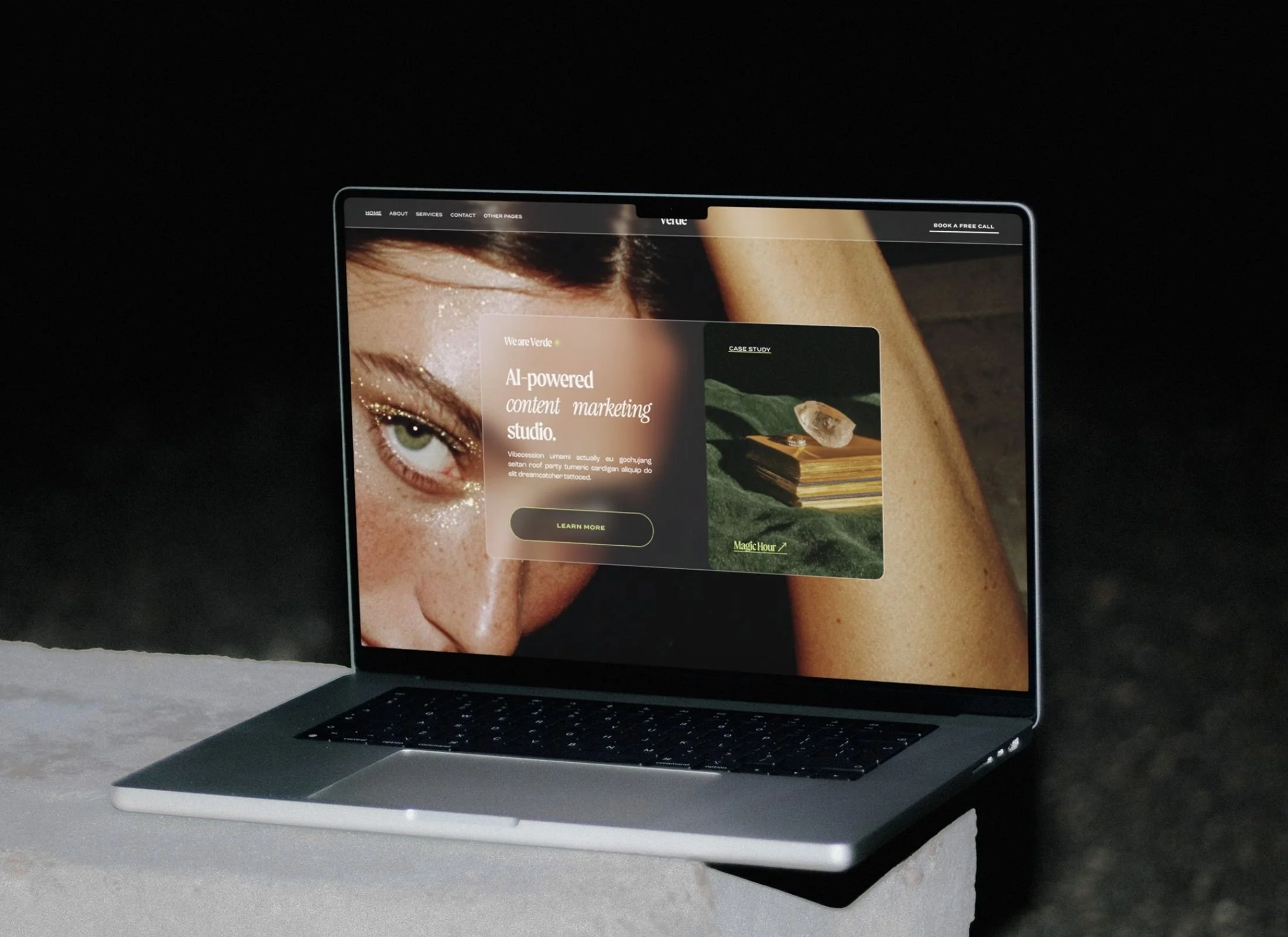 Open laptop showing a webpage with a close-up of a woman with glitter makeup and another smaller image of a book with a crystal on top.