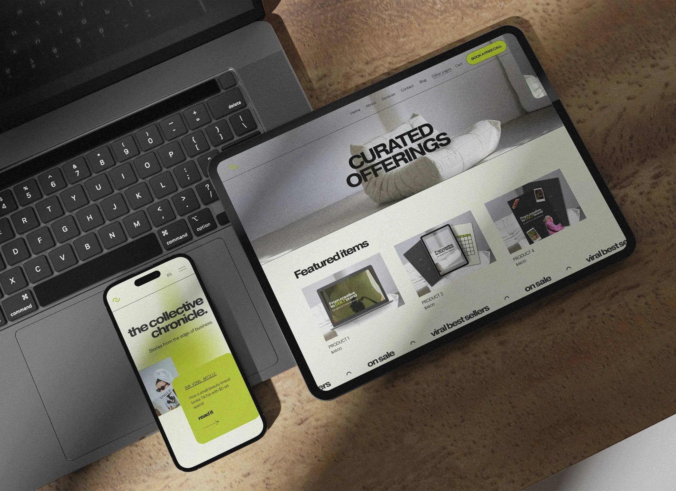 Laptop keyboard, smartphone, and tablet on a wooden surface displaying a website with curated product offerings and featured items.