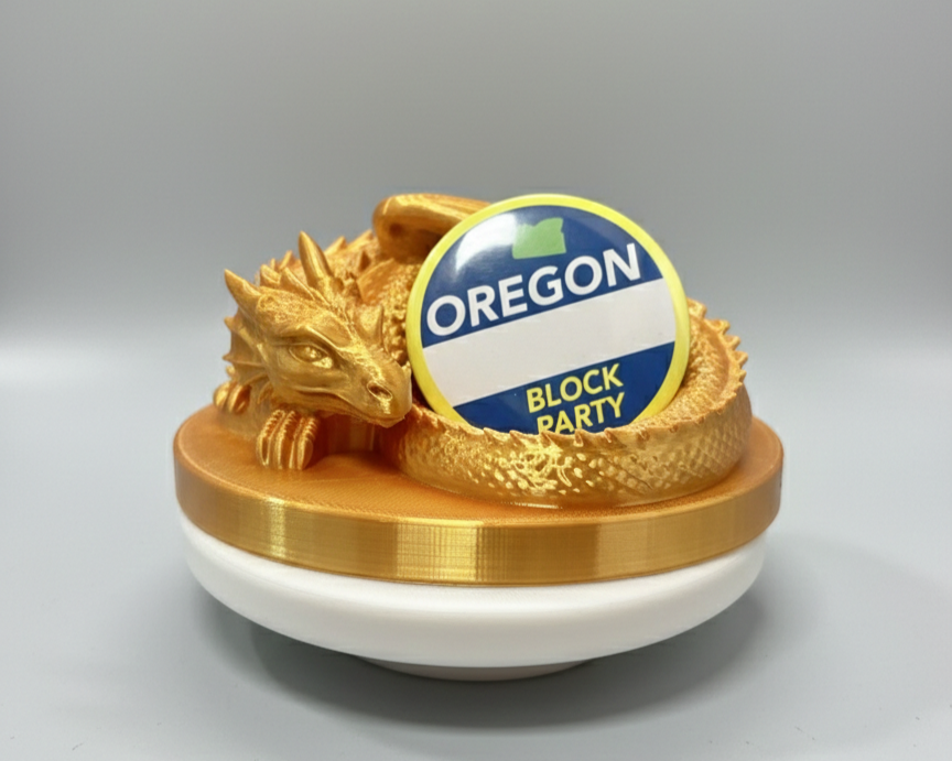 3D printed Custom-Made Golden dragon Geocoin Holder with a circular sticker reading 'Oregon Block Party.