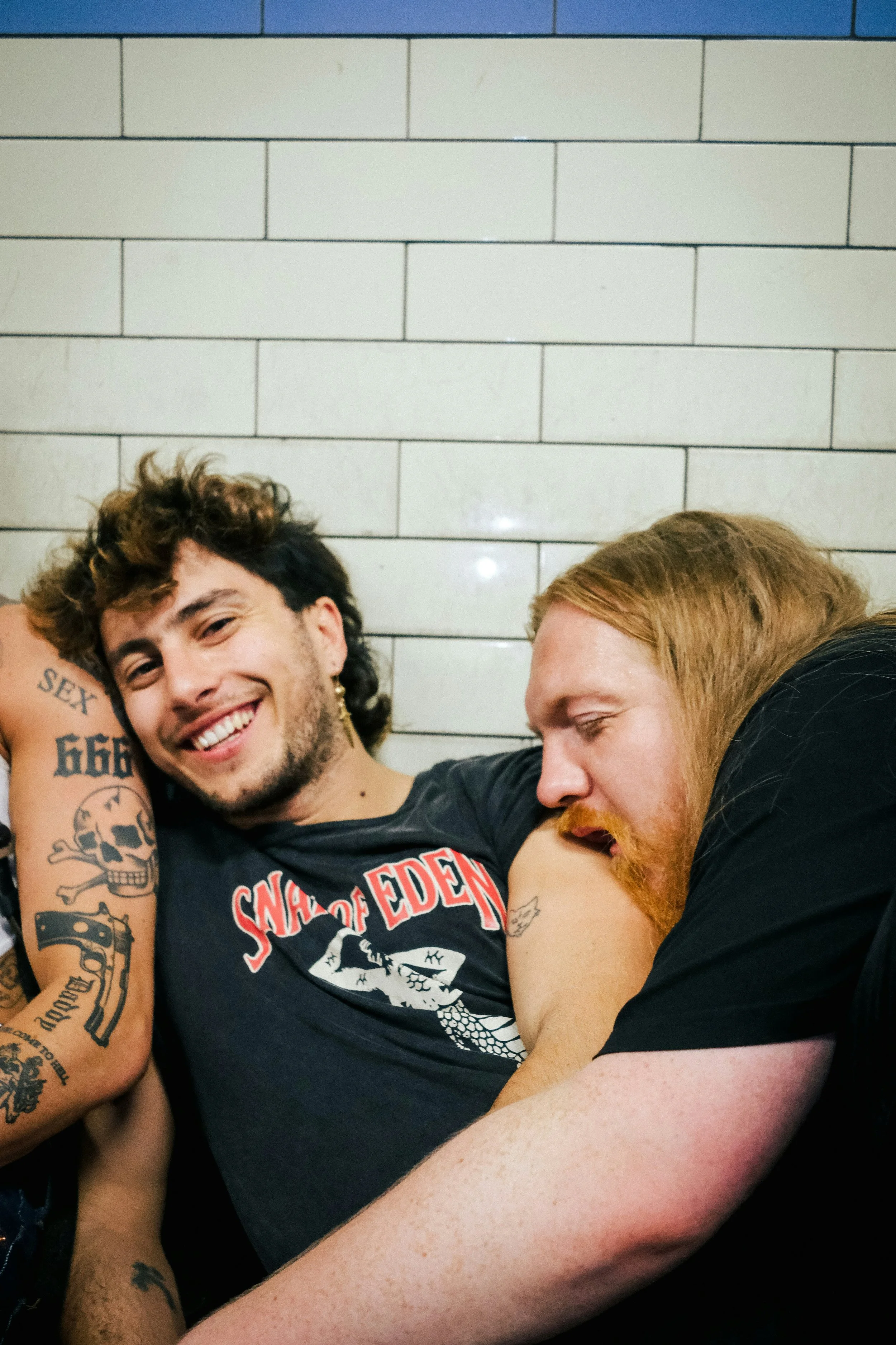 Group of partners or friends in alternative black clothing sharing a playful, affectionate moment together.