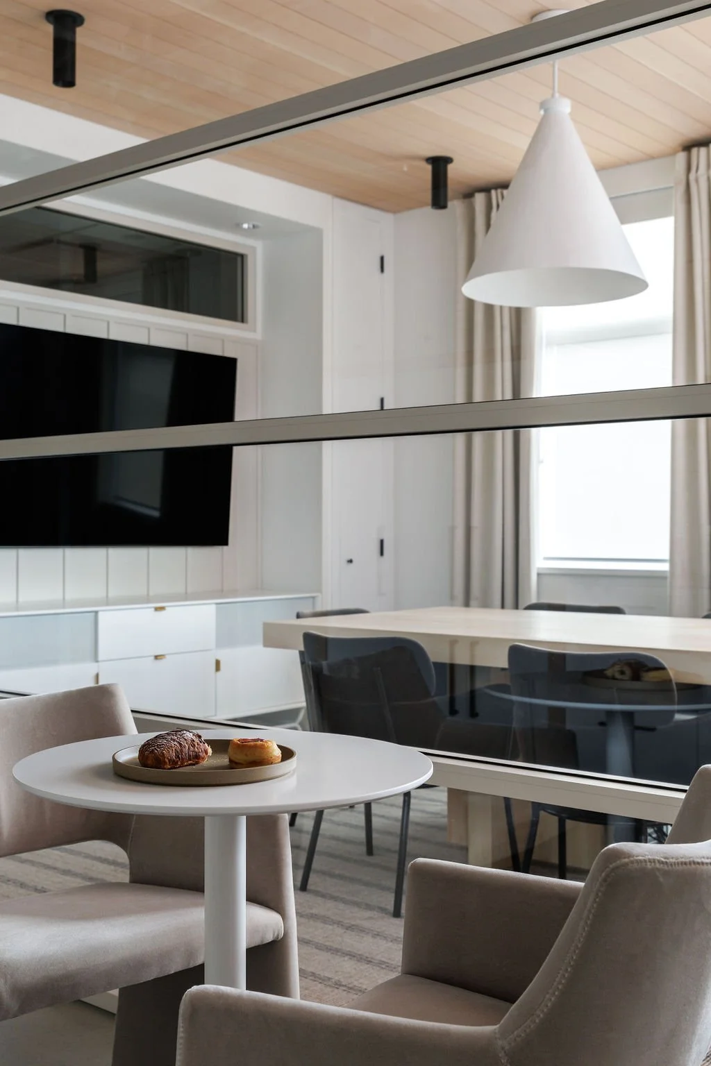 Close-up photo of glass wall looking into boardroom with bistro table. 